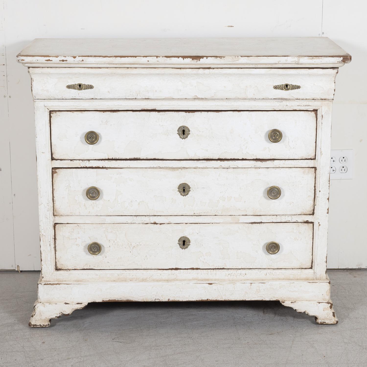 A 19th century French Louis Philippe style hand painted four-drawer commode from Uzes, a captivating village in the Occitane region of Southern France, circa 1880s. This antique French chest of drawers features a beveled plank top above a secret
