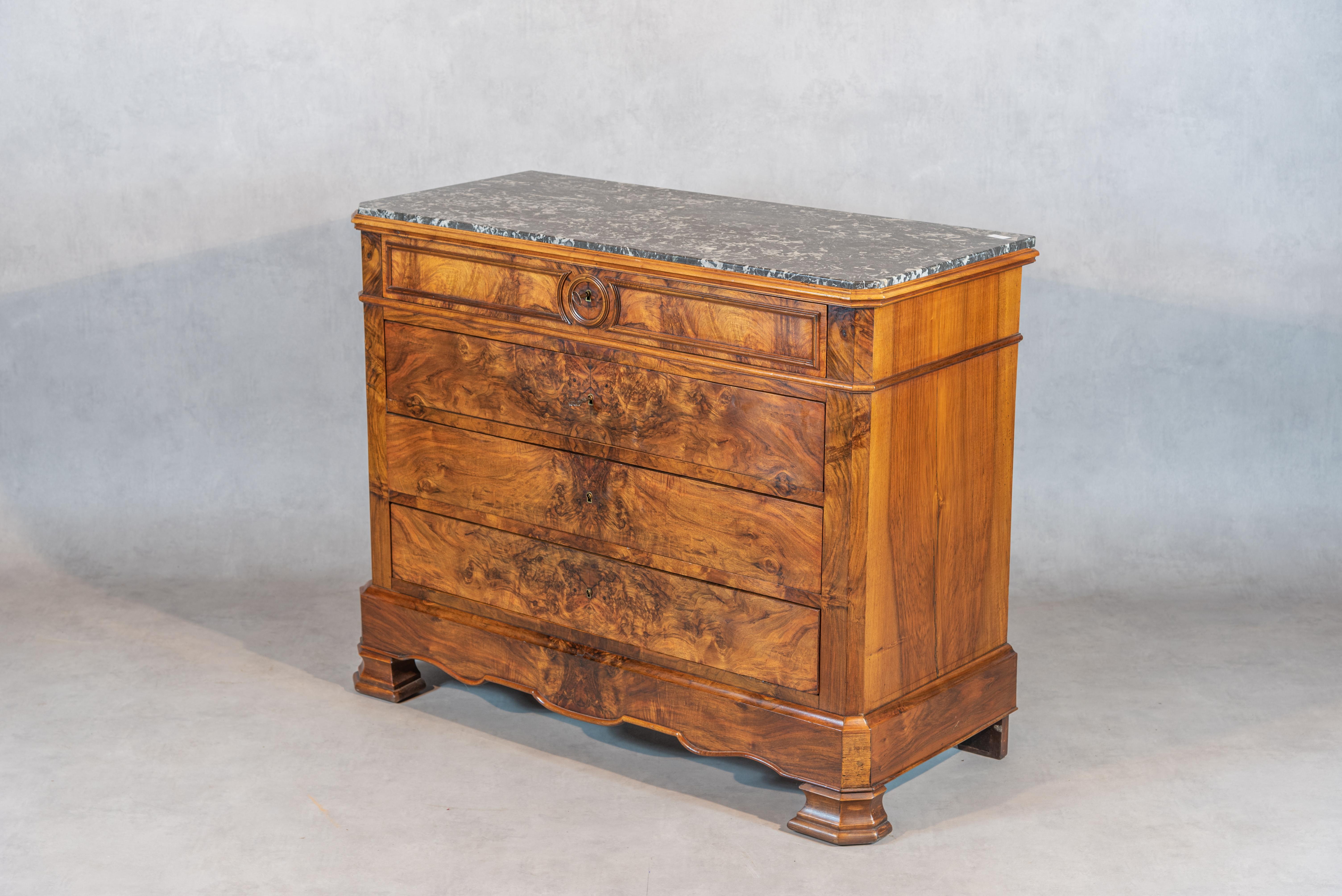 Indulge in the timeless elegance of the 19th century with this stunning French Louis Philippe Style Walnut Commode. Crafted with the utmost attention to detail, this commode boasts a stunning symmetrical walnut veneer, complete with spectacular