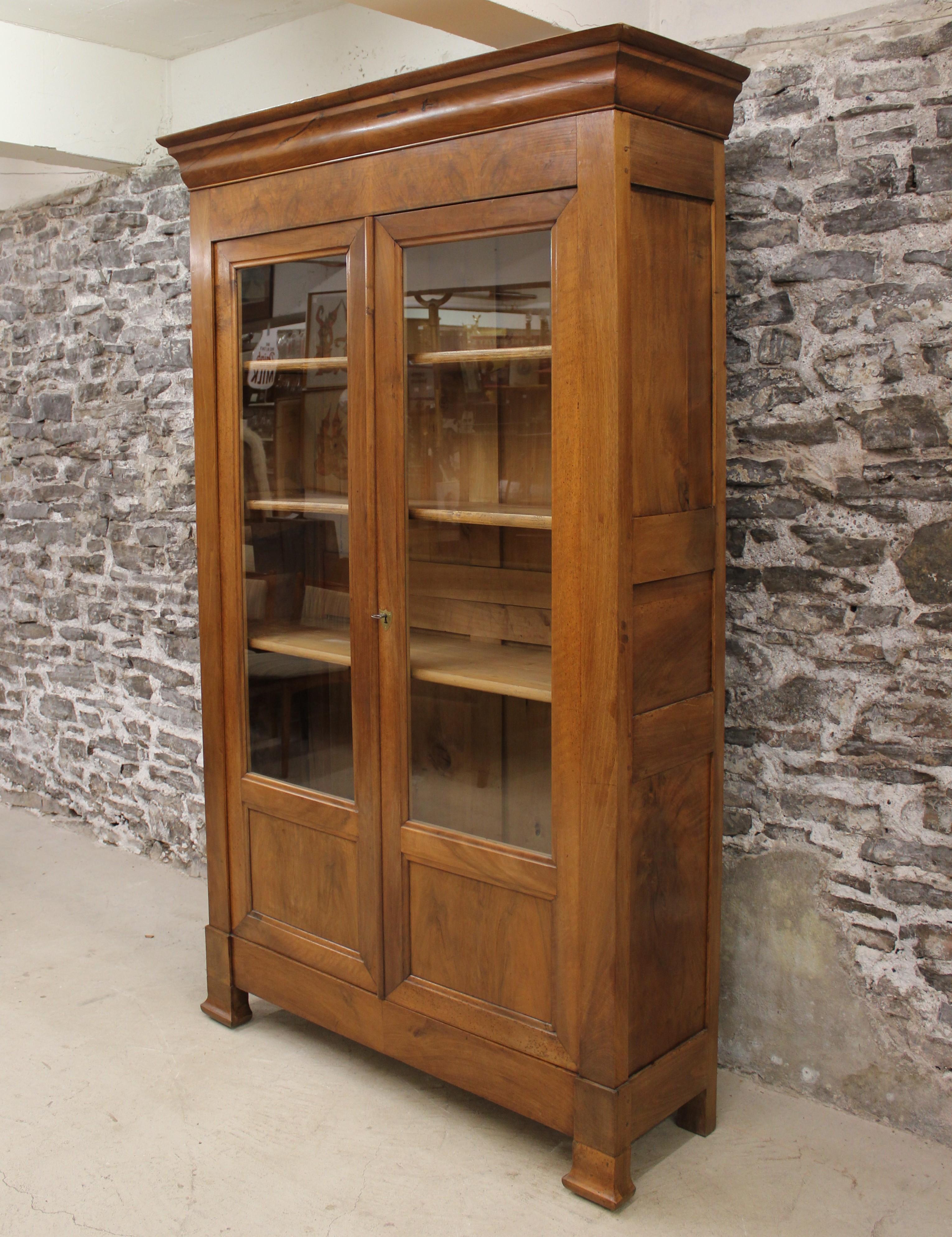 This 19th century French Louis Philippe style walnut cabinet offer a Classic French design. It has two glass doors and provides ample storage. This would be a perfect fit for either a kitchen or library.