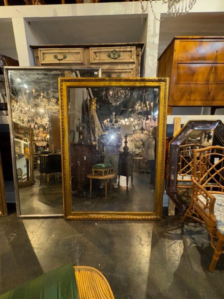 Le miroir en bois doré transitionnel Louis Philippe du 19e siècle présente un superbe design antique avec une finition de cadre en miroir. Ce miroir présente des détails complexes en bois doré caractéristiques du style Louis Philippe, ajoutant une