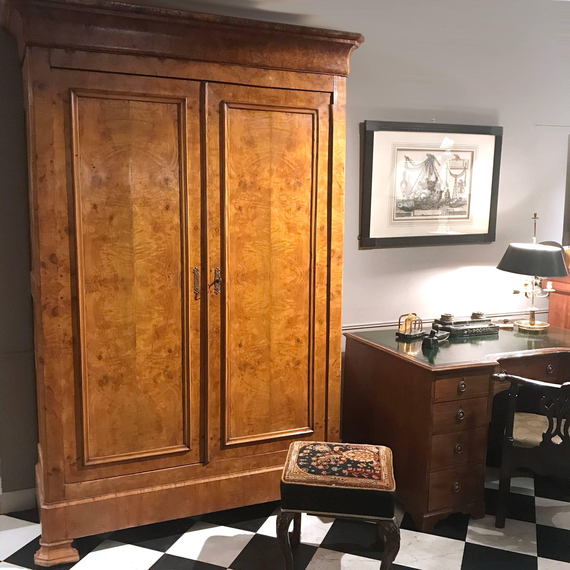 This mid-19th century Louis Philippe-period armoire is distinguished by its architectural feel. The two large panelled doors, with brass escutcheon and key, open to three deep shelves.