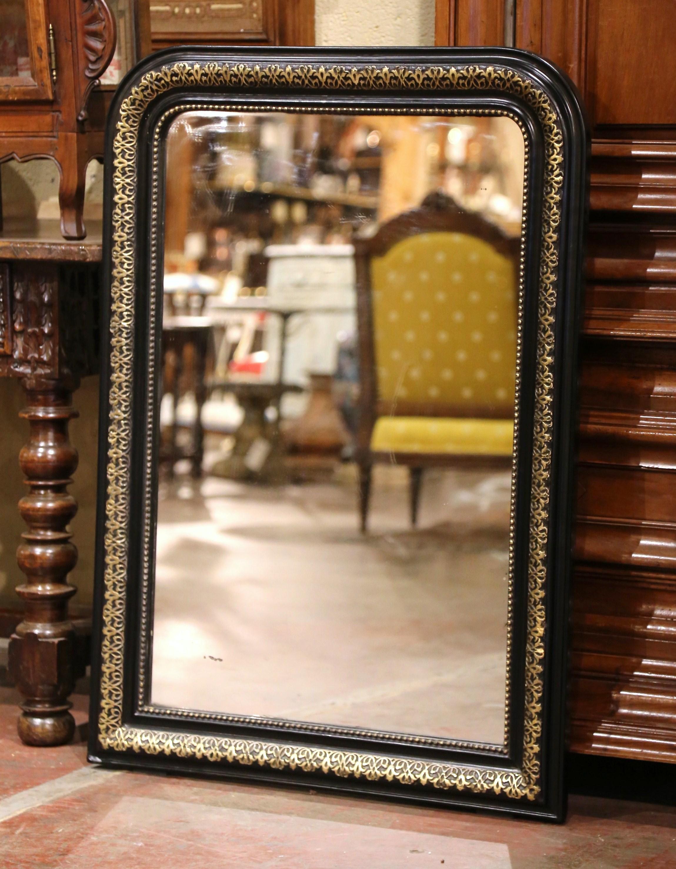 Decorate a powder room or a bedroom with this elegant antique blackened and gilt wall mirror. Crafted in northern France circa 1870, the blackened and gold leaf frame is decorated with hand carved repousse foliage motifs further embellished with