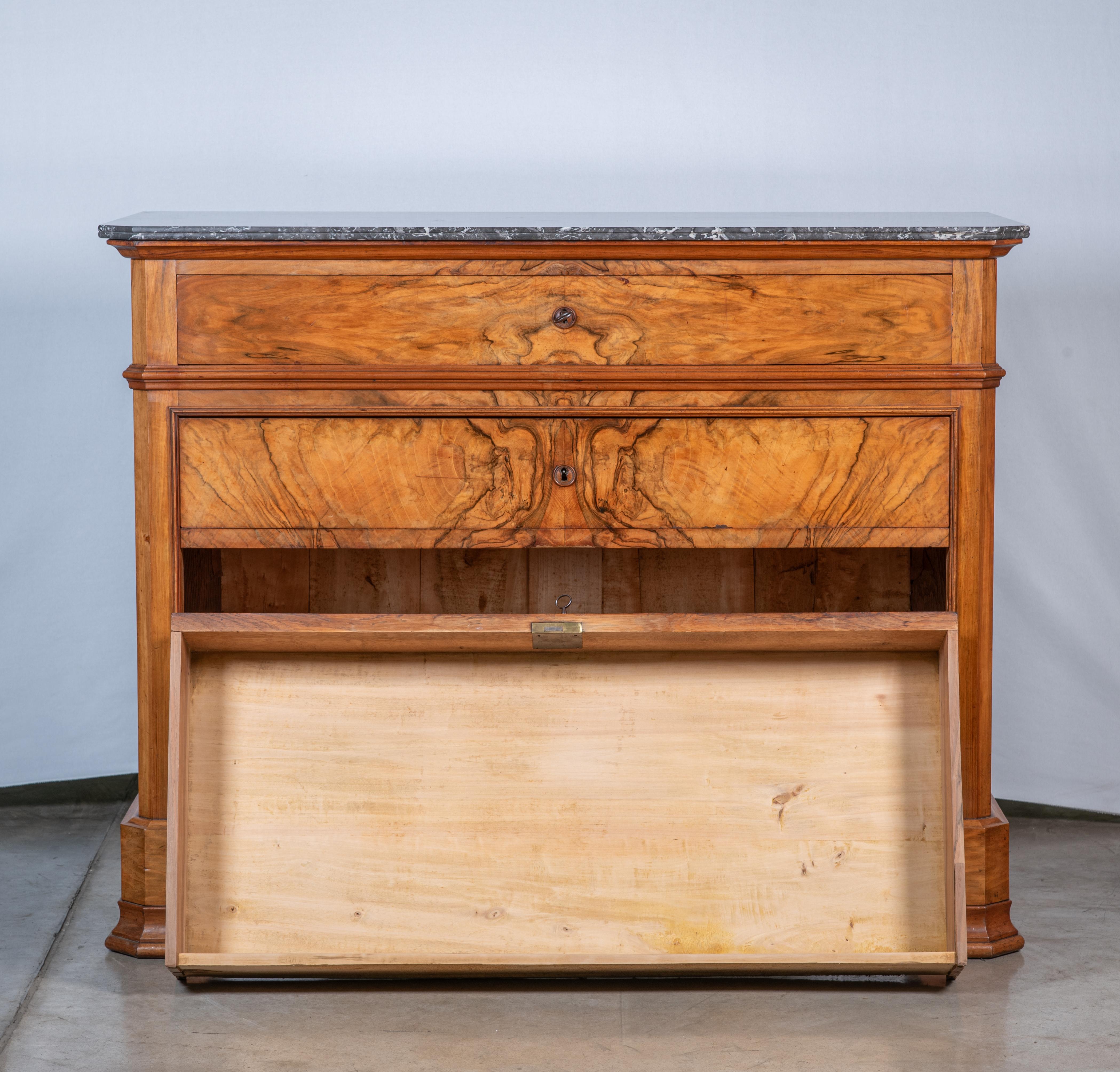 Indulge in the timeless elegance of the 19th Century French Louis Philippe Walnut Veneer Commode, a masterpiece of sophistication and craftsmanship. This exquisite piece exemplifies the refined aesthetics of the Louis Philippe era, showcasing the