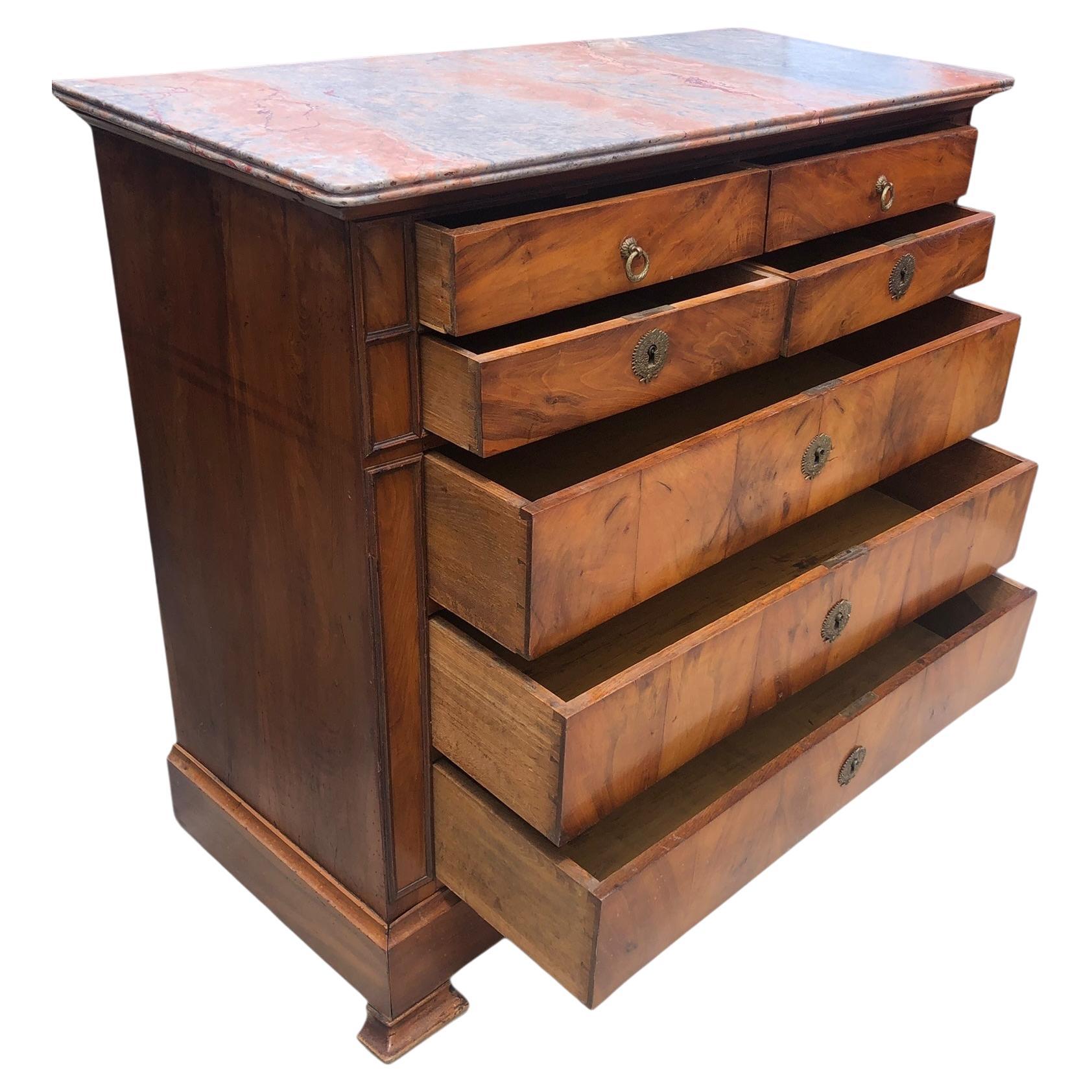 Commode Louis Philippe du 19ème siècle en cerisier. L'ensemble du coffret est constitué de placage de cerisier merveilleusement grainé et assorti aux livres. Composée de quatre tiroirs sur quatre, elle repose sur des pieds en console typiques de