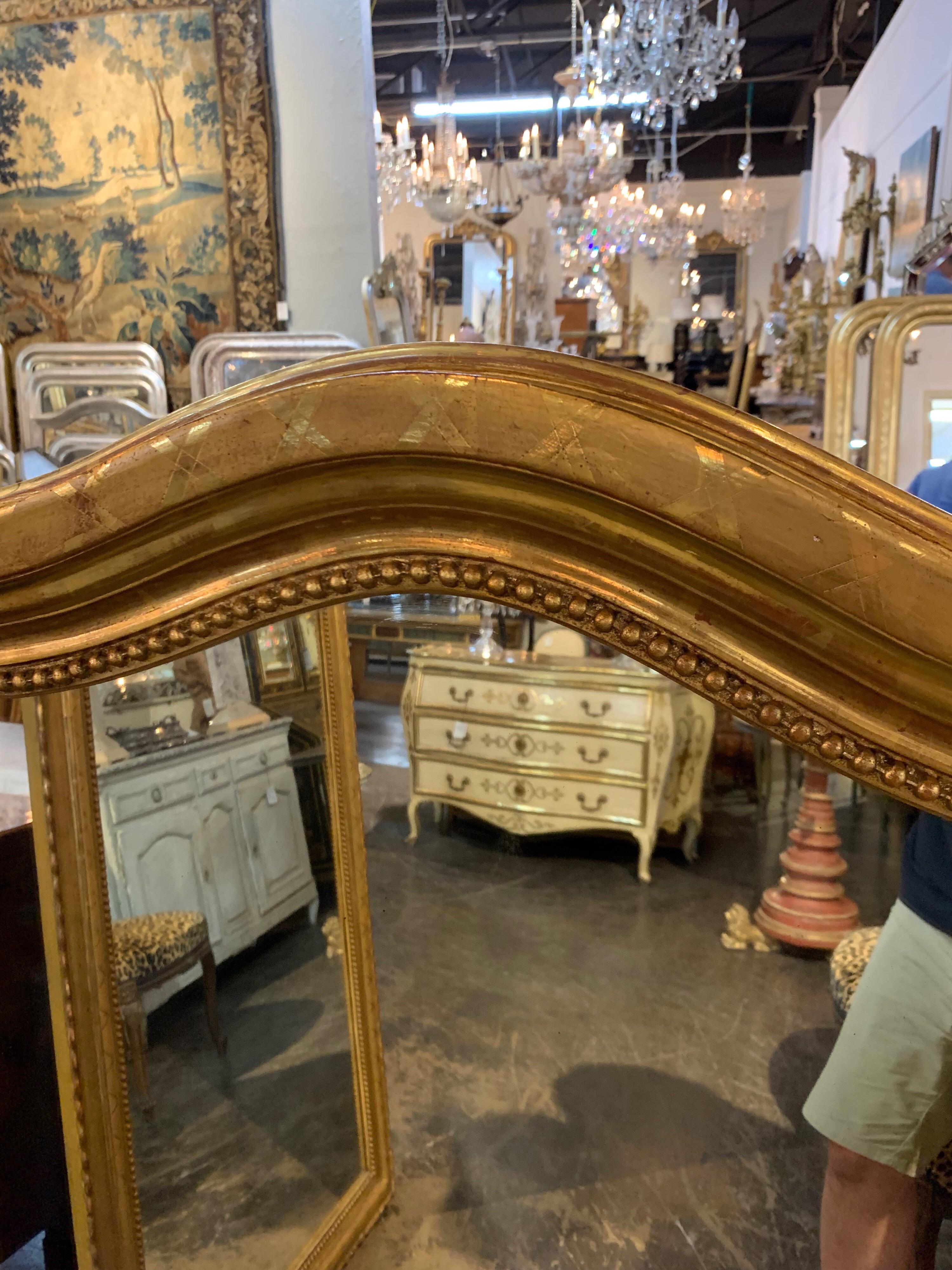 Gorgeous 19th century Louis Philippe gold gilded mirror with X-pattern. Very nice beaded details and arched shape. A lovely mirror for a fine home.