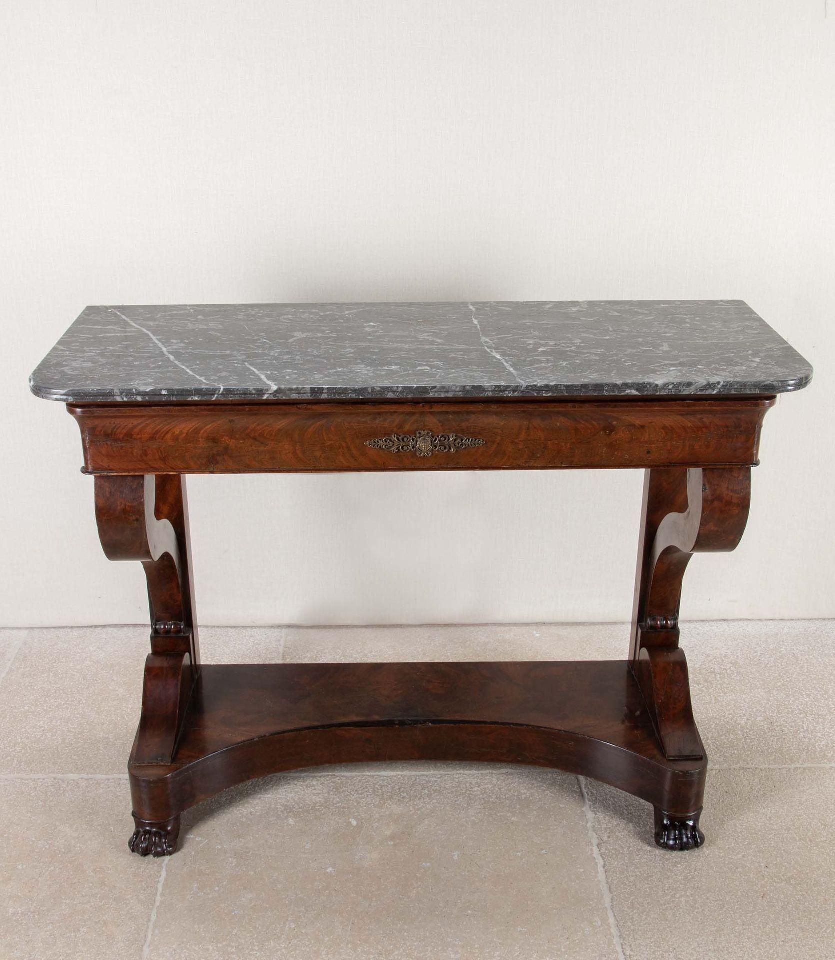 19th Century French Louis Phillippe mahogany console table.
With a variegated black marble top and double scrolled legs ending in lion's paws. It has the additional benefit, on it's top tier,  of a full width drawer.
Circa 1830.