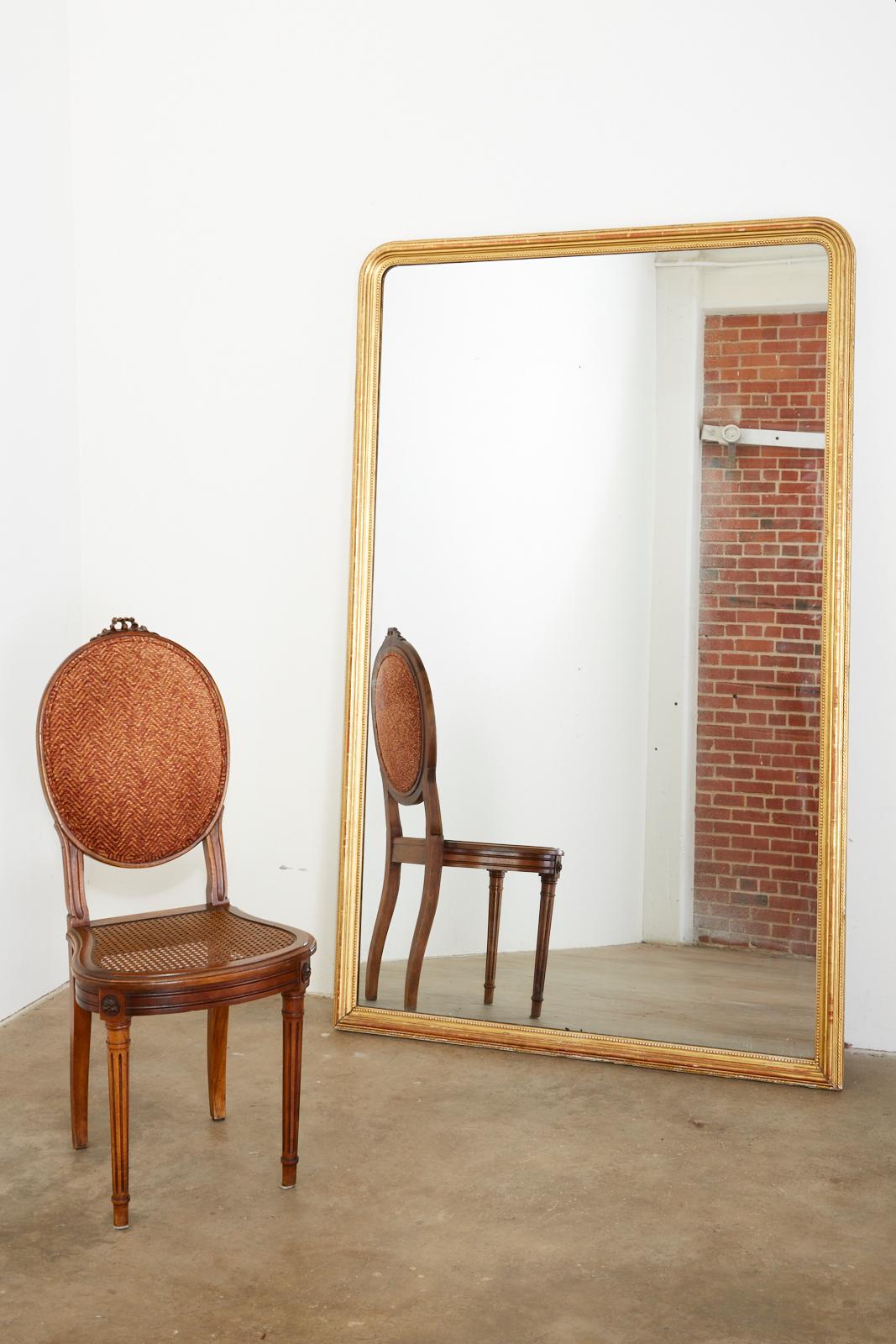 Large 19th century French Louis Phillippe pier mirror or floor mirror. Features a beautifully decorated giltwood frame with an inner beaded border and a rope motif trim on the edges. Rich, aged patina on the giltwood finish. From an estate in