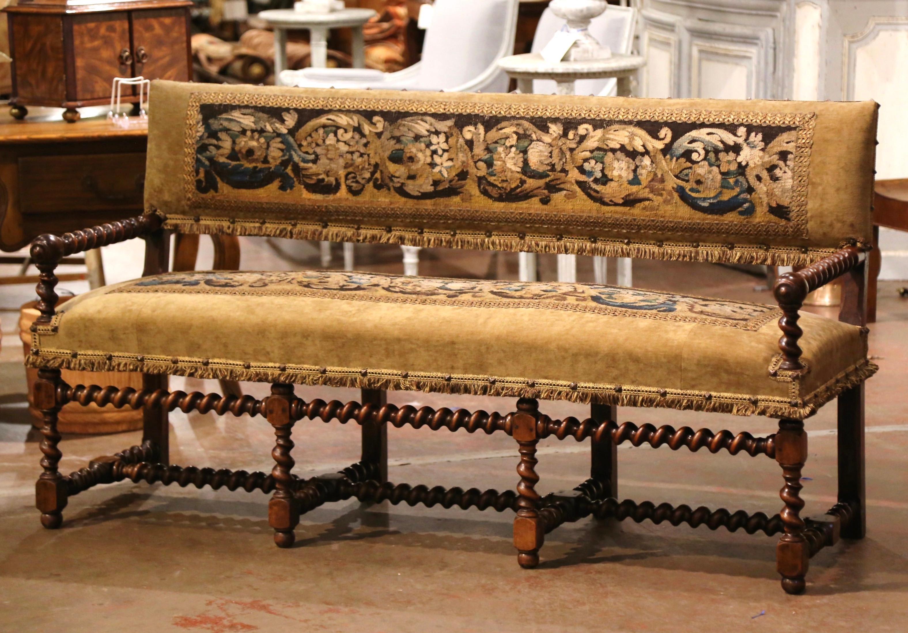 Add extra seating to a hallway, den or living room with this elegant antique bench with back. Crafted in southern France circa 1850, this fruit wood seating stands on eight carved barley twist legs embellished with matching barley twist armrests.