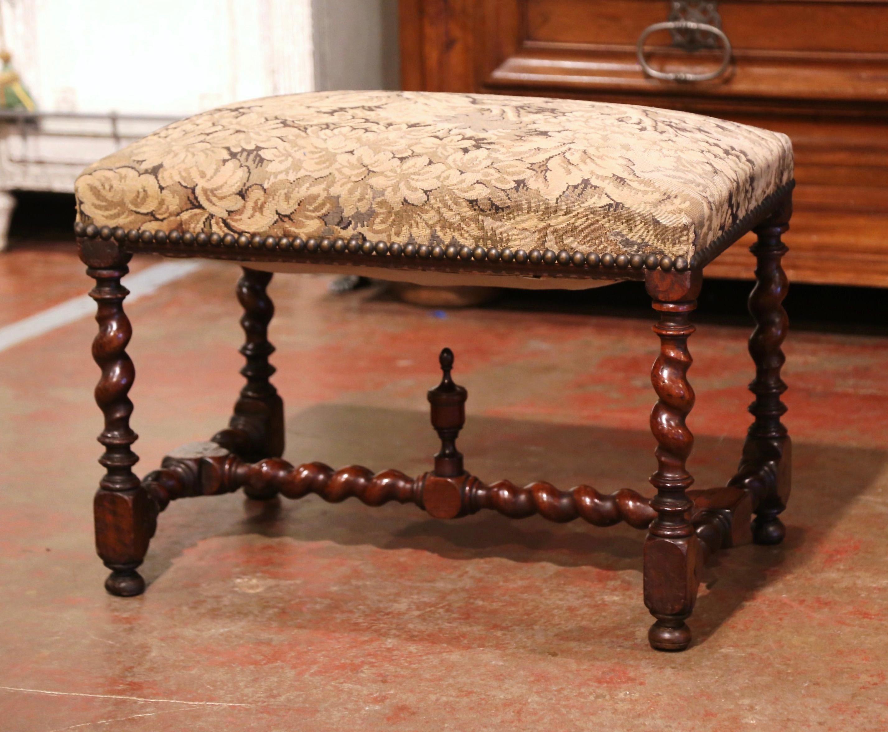 Add extra seating to a hallway, den or living room with this elegant, antique bench. Crafted in France circa 1860, this fruit wood piece features four delicately carved barley twist legs over a matching stretcher, embellished with a central finial.