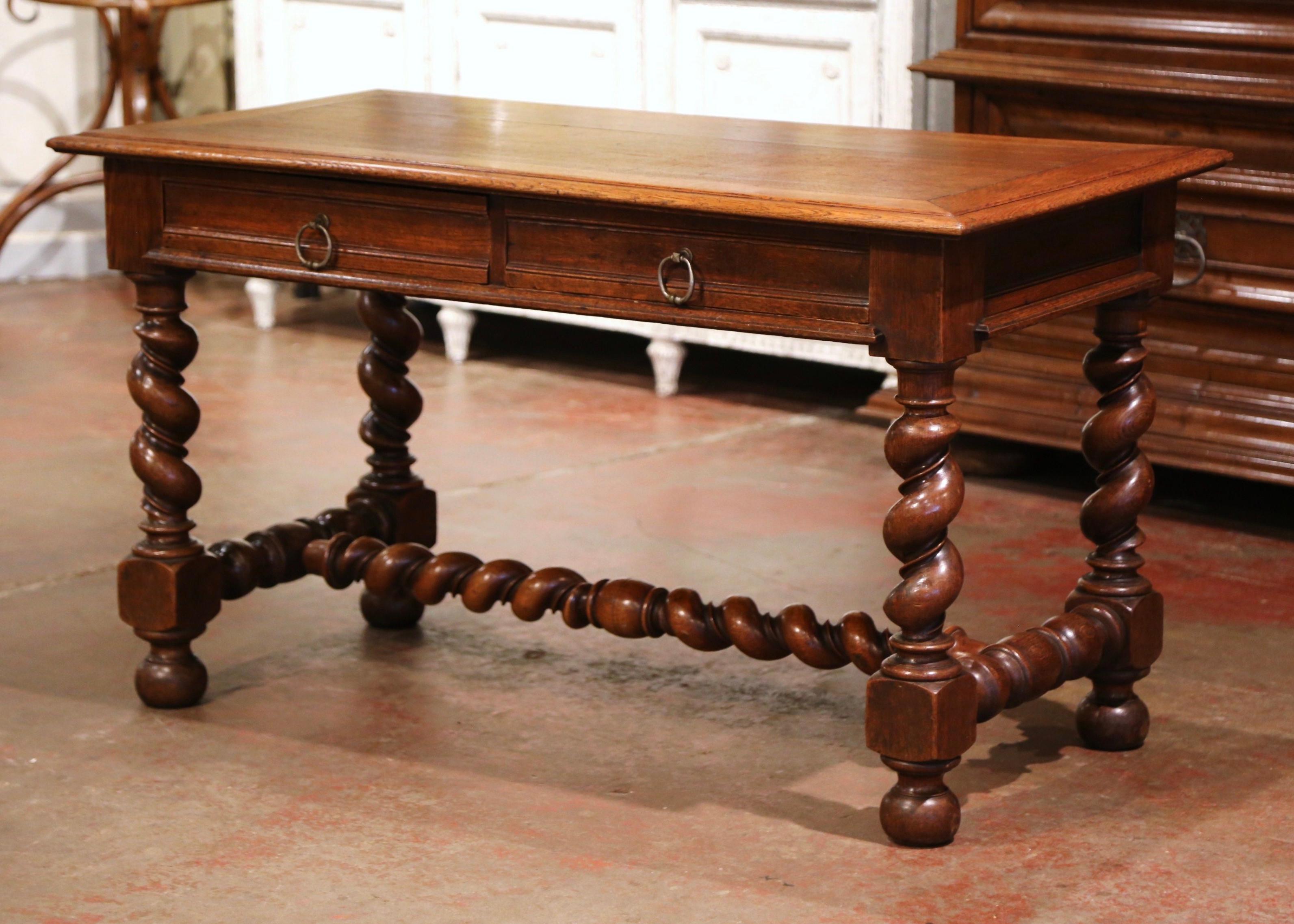 Crafted in Northern France, circa 1870, the antique writing table stands on four thick carved barley twist legs ending with bun feet, and embellished with an elegant stretcher at the base. The side table features two drawers across the front