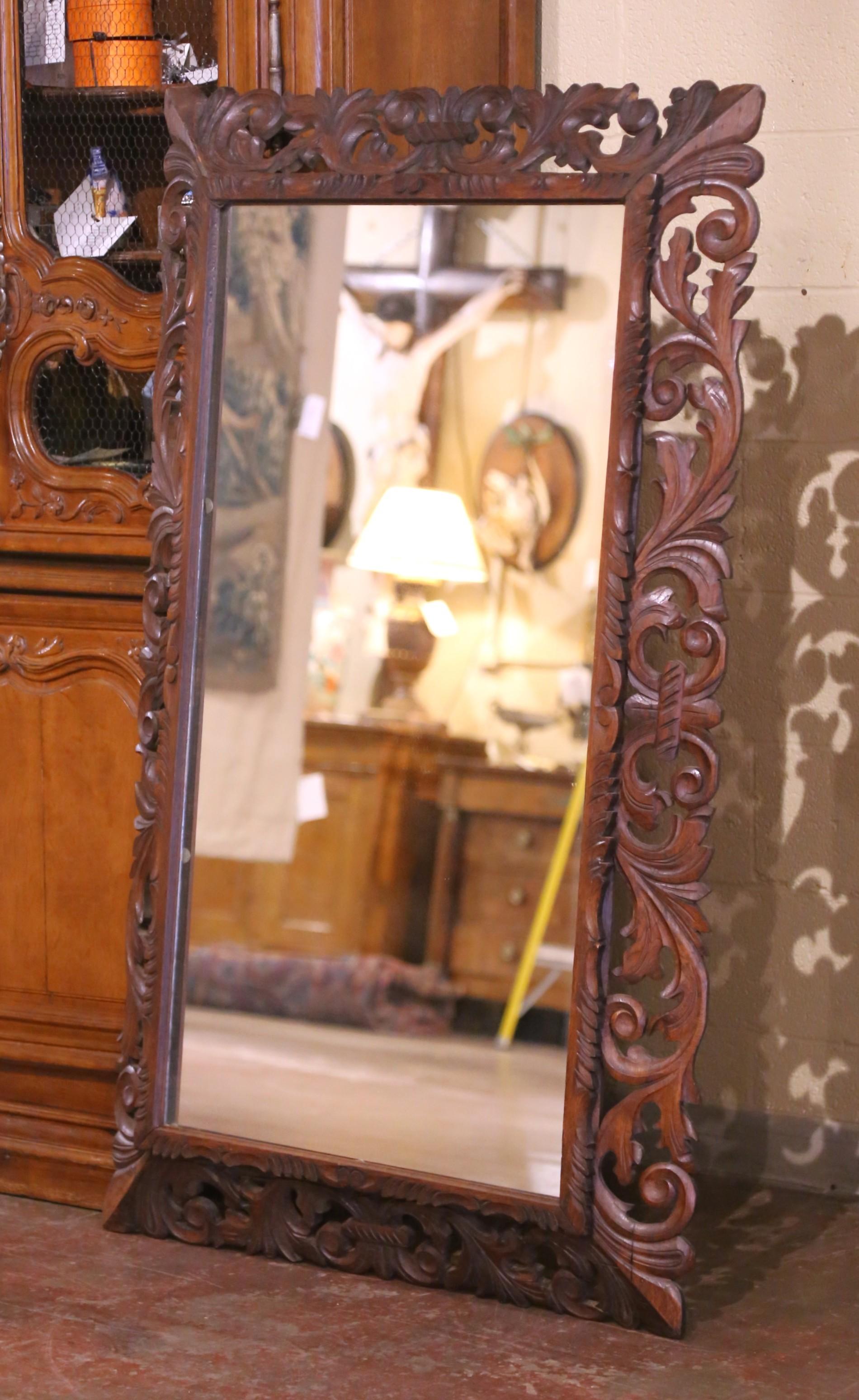 Fabriqué en France vers 1880, et construit en bois de chêne, ce miroir ancien est de forme rectangulaire et peut être suspendu verticalement ou horizontalement. Le cadre de style forêt noire est décoré de feuilles d'acanthe et de motifs floraux