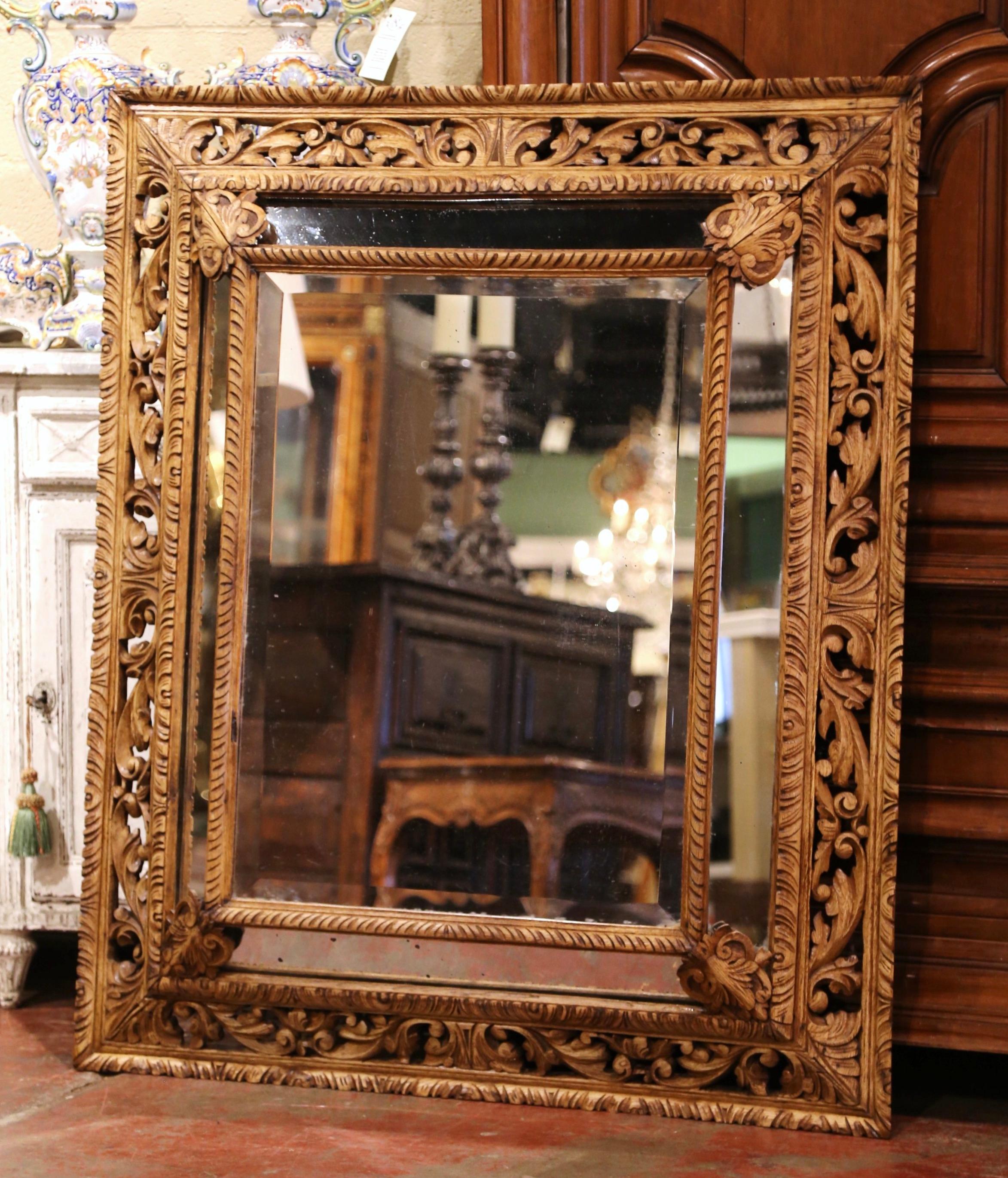 Crafted in France circa 1870, and built of oak wood, the large mirror is rectangular in shape. The wall decor features a center beveled mirror with mercury glass, and four smaller mirrors around the frame with floral rosettes in each corner. The