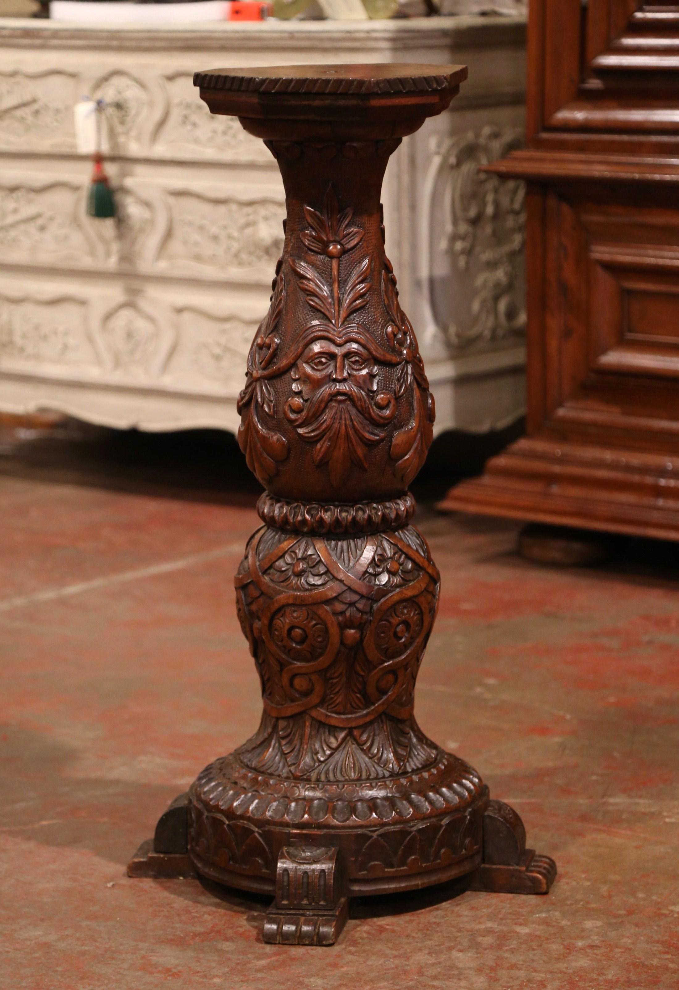 This elegant antique pedestal was crafted in northern France, circa 1870. Round in shape and made of walnut, the heavily carved column stands on four paw feet over a turned stem decorated with foliage and vine embellished with Bacchus head