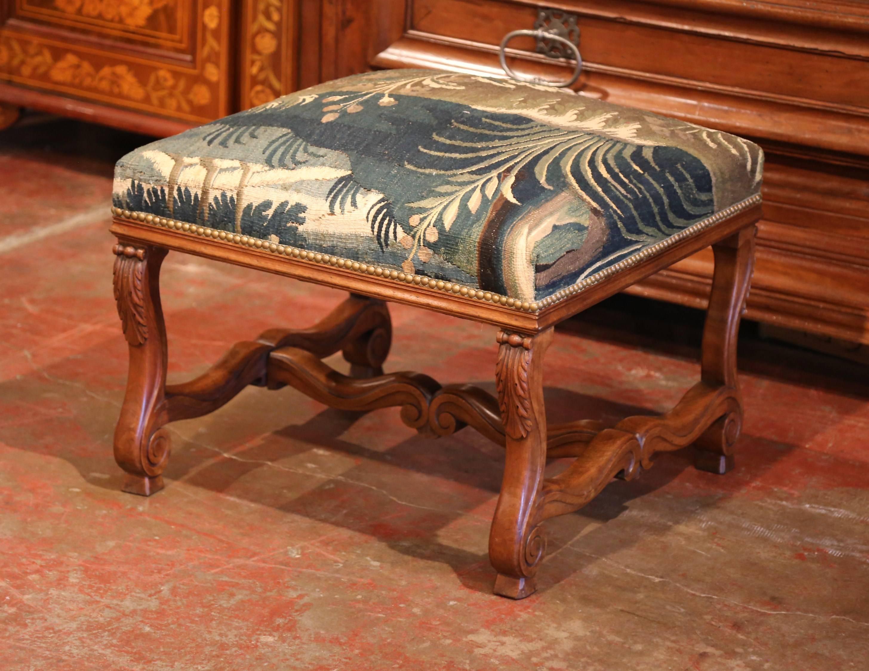 This elegant antique fruitwood stool was crafted in Southern France, circa 1880. The square seat features four scrolled legs with hand carved acanthus leaves and an elaborate stretcher. The seat has been reupholstered with a colorful, 18th Century