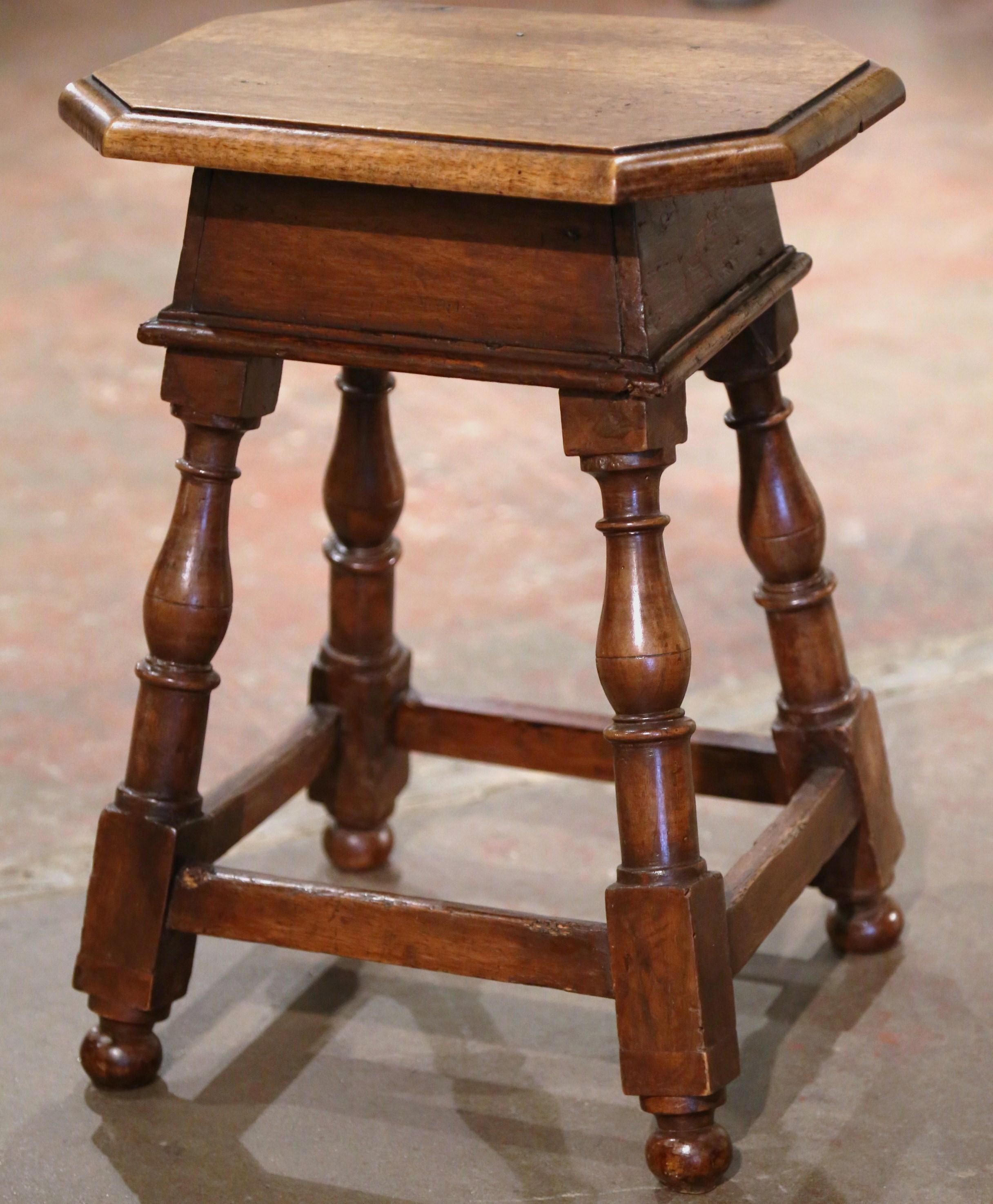 This elegant antique stool was created in Northern France, circa 1870. Built of walnut and octagonal in shape, the seating stands on four turned legs connected with a sturdy stretcher at the bottom. The rustic Louis XIII style stool is in excellent