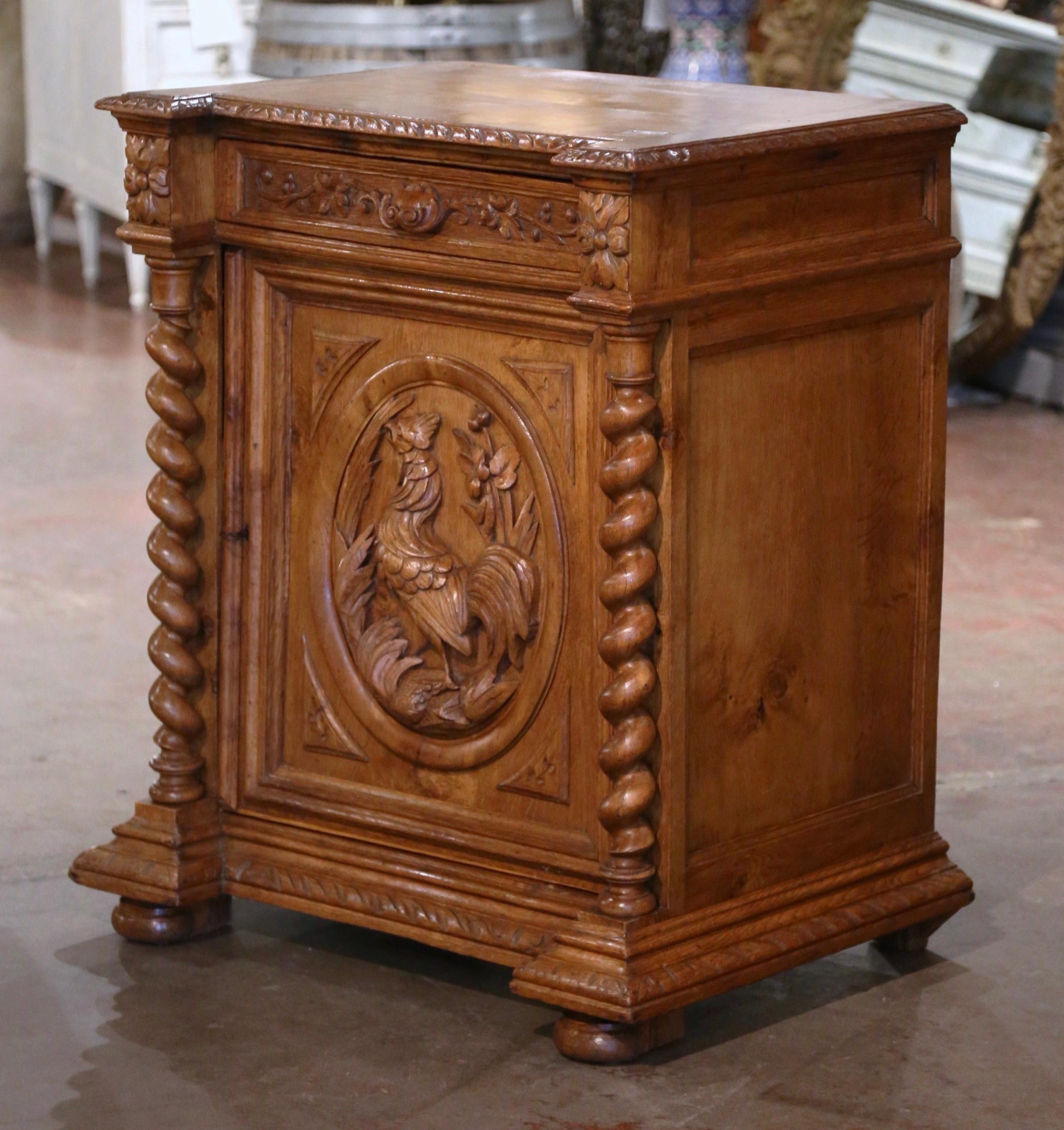 Decorate an entry, study or office with this elegant antique jelly cabinet with carved rooster. Crafted in France, circa 1870 and built of oak, the small buffet stands on a recessed molded plinth base over bun feet. The 