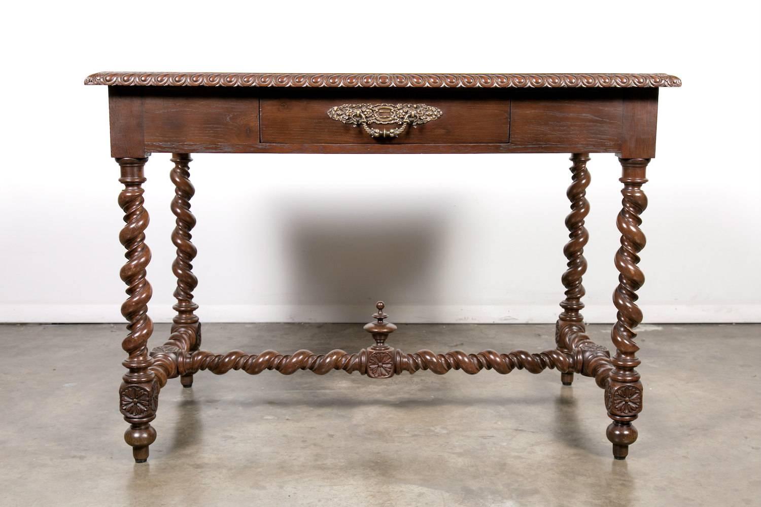 A fine 19th century French Louis XIII style writing table or bureau plat, having a rectangular top with a gadrooned beveled edge above a deep apron with a single drawer. This hand-carved solid oak desk is raised on four intricately hand-turned