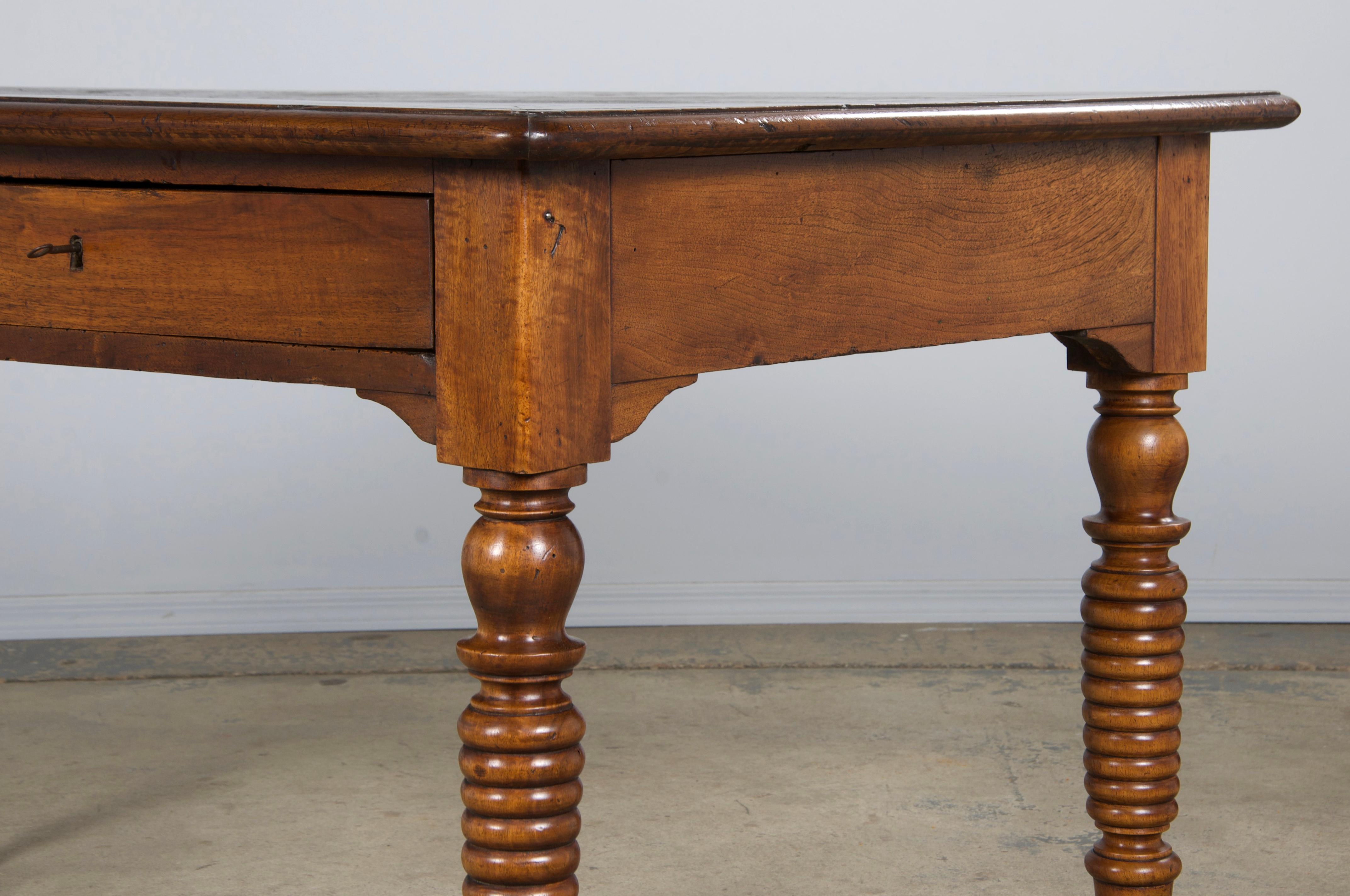 Incantevole tavolino rustico francese della metà del XIX secolo in stile Luigi XIII, proveniente dalla Provenza. Realizzato a mano in noce massiccio, presenta due cassetti spaziosi con una tradizionale lavorazione a coda di rondine. Strutturalmente