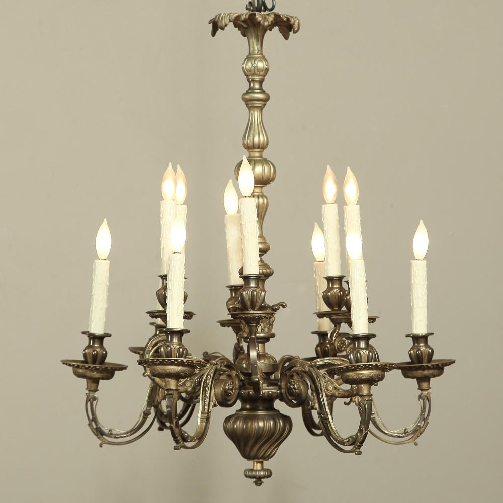 19th Century French Louis XIV Bronze Chandelier with 12 Lights features stunning foliate motifs expressed in a variety of forms, appearing from the tips of the bobeches to the pendant finial below, and rising to the top of the piece.  At the top we