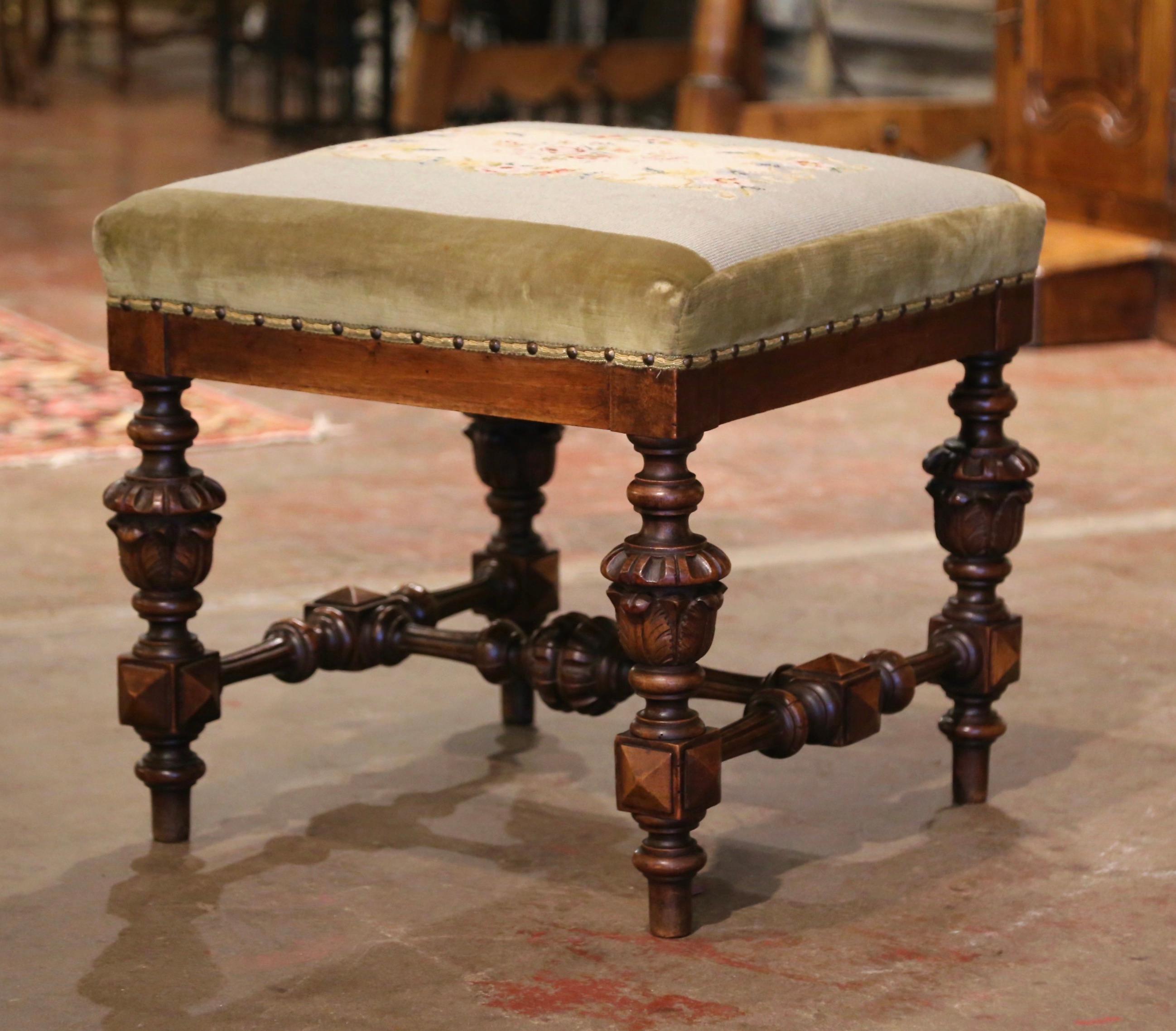 This elegant antique fruitwood stool was crafted in Southern France, circa 1870. Square in shape, the stool stands on heavily turned legs decorated with hand carved diamond shape medallions over an elaborate stretcher. The seat is upholstered with