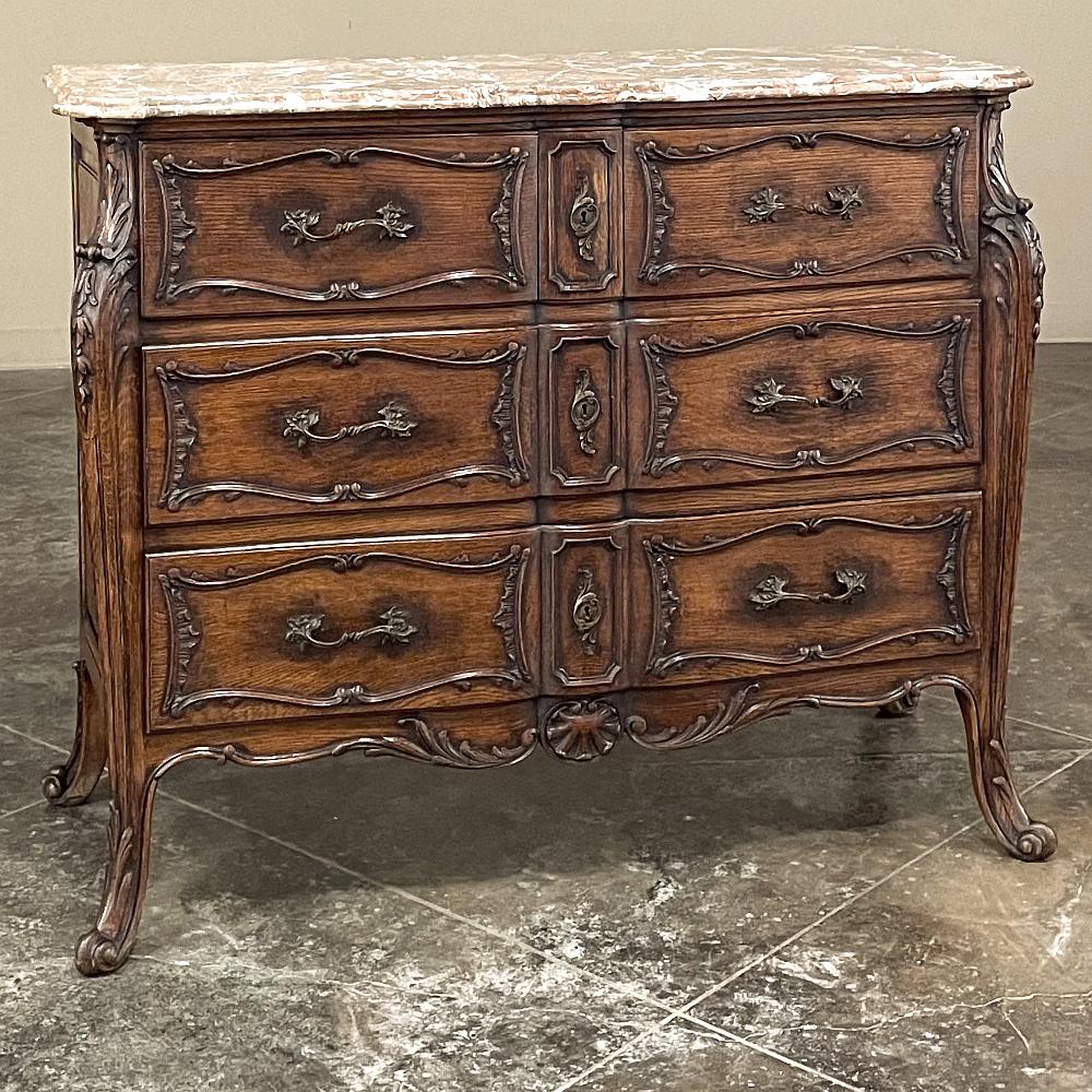 19th Century French Louis XIV marble top commode ~ chest of drawers exudes a stately elegance that is truly timeless! Hand-crafted from dense, old-growth oak, it features a casework that is framed by full length scrolled cornerposts carved with