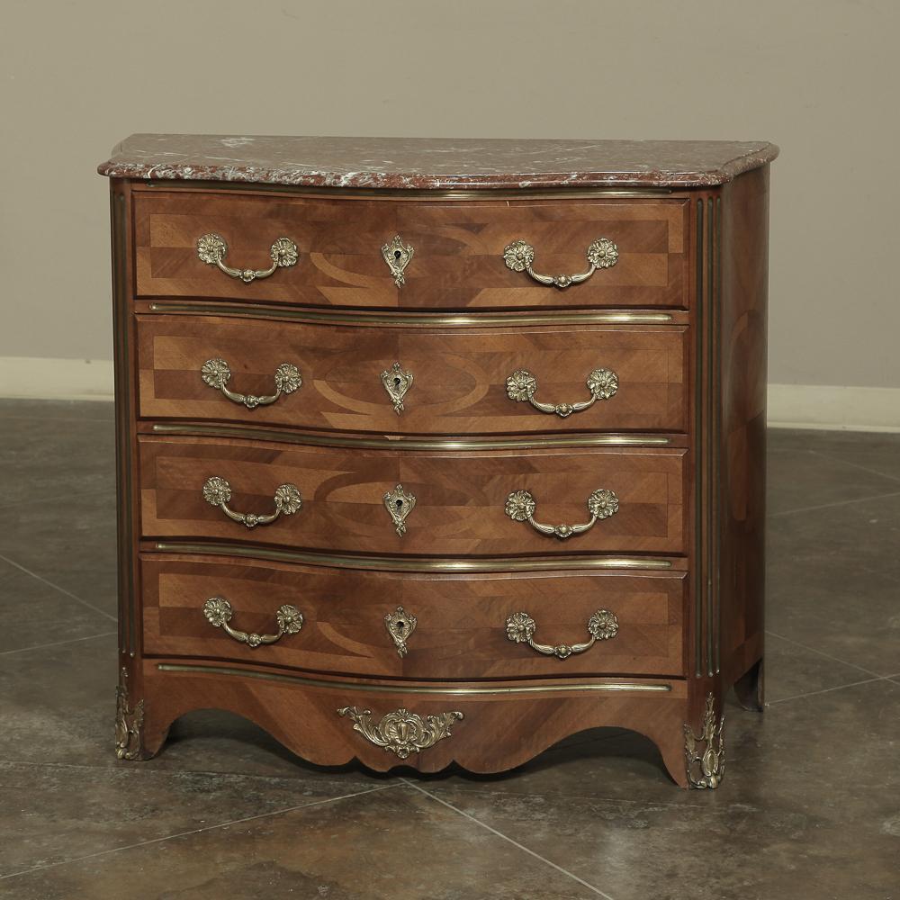 19th Century French Louis XIV Marble Top Commode with Marquetry features timeless French flair with bronze d’ore pulls and key-guards combined with serpentine sides!  Original rouge marble was contoured and beveled to follow the casework below, and