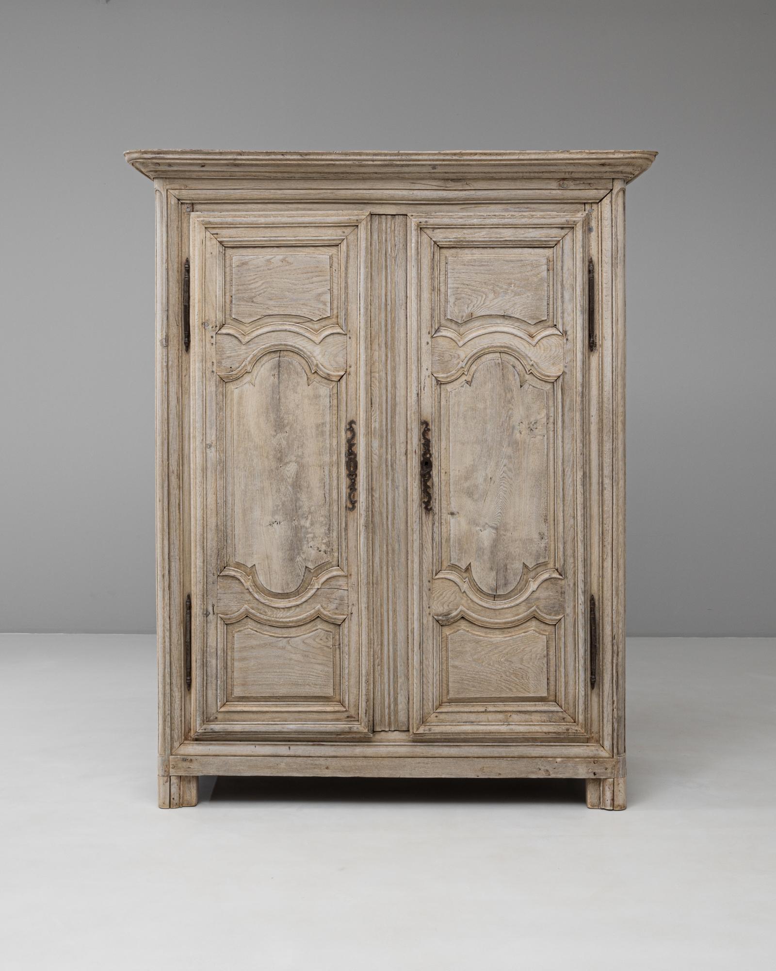 Questo mobile francese in quercia Luigi XIV del XIX secolo è un pezzo imponente che riflette la grandezza e la simmetria tipiche del periodo. Realizzato in legno massiccio di quercia, il mobile è caratterizzato da ante a pannelli intagliati con
