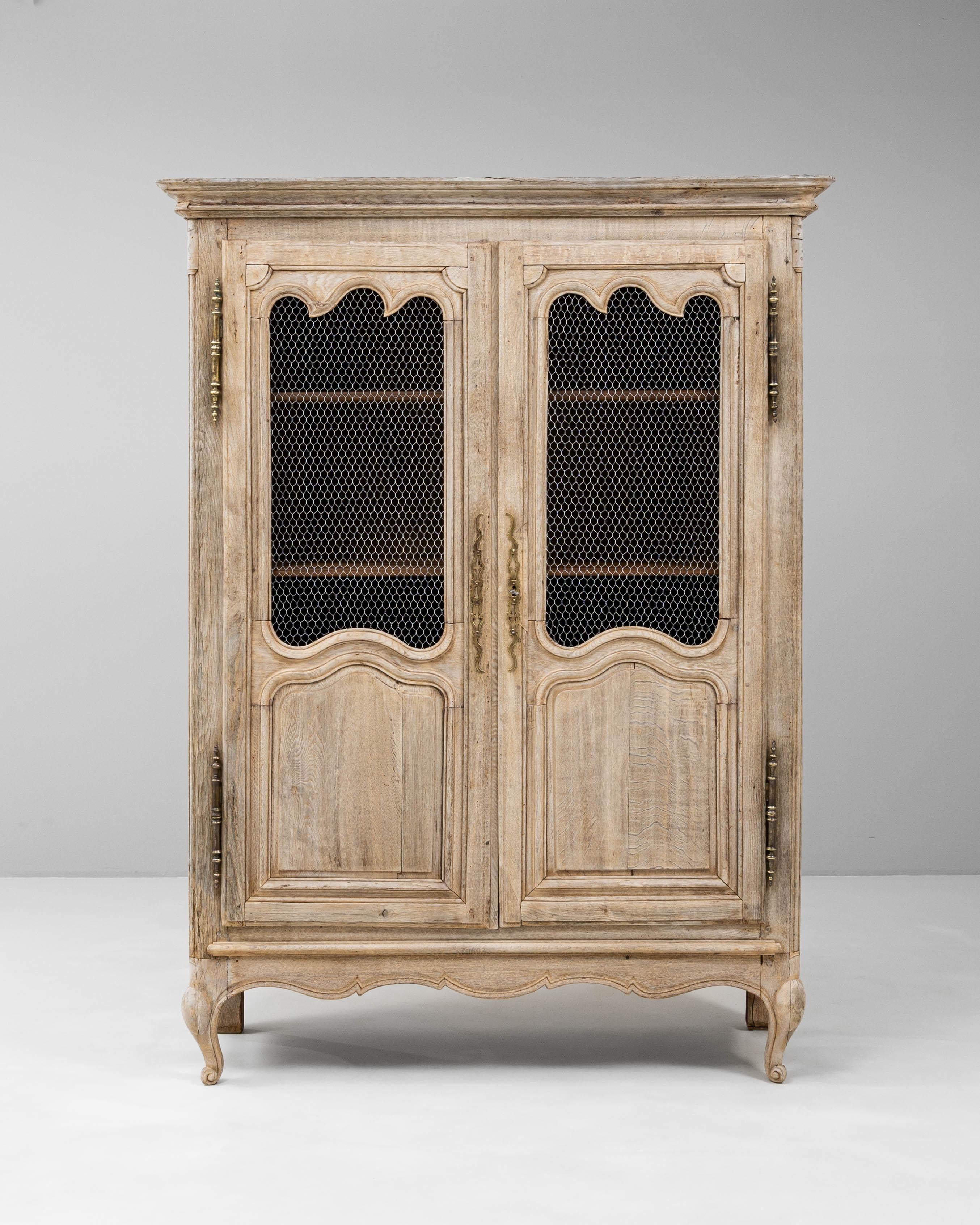Questo mobile francese in quercia Luigi XIV del XIX secolo esemplifica l'eleganza e la maestria del design francese di provincia. Realizzato in rovere massiccio, il mobile presenta due ante a pannelli con modanature sagomate e inserti decorativi in