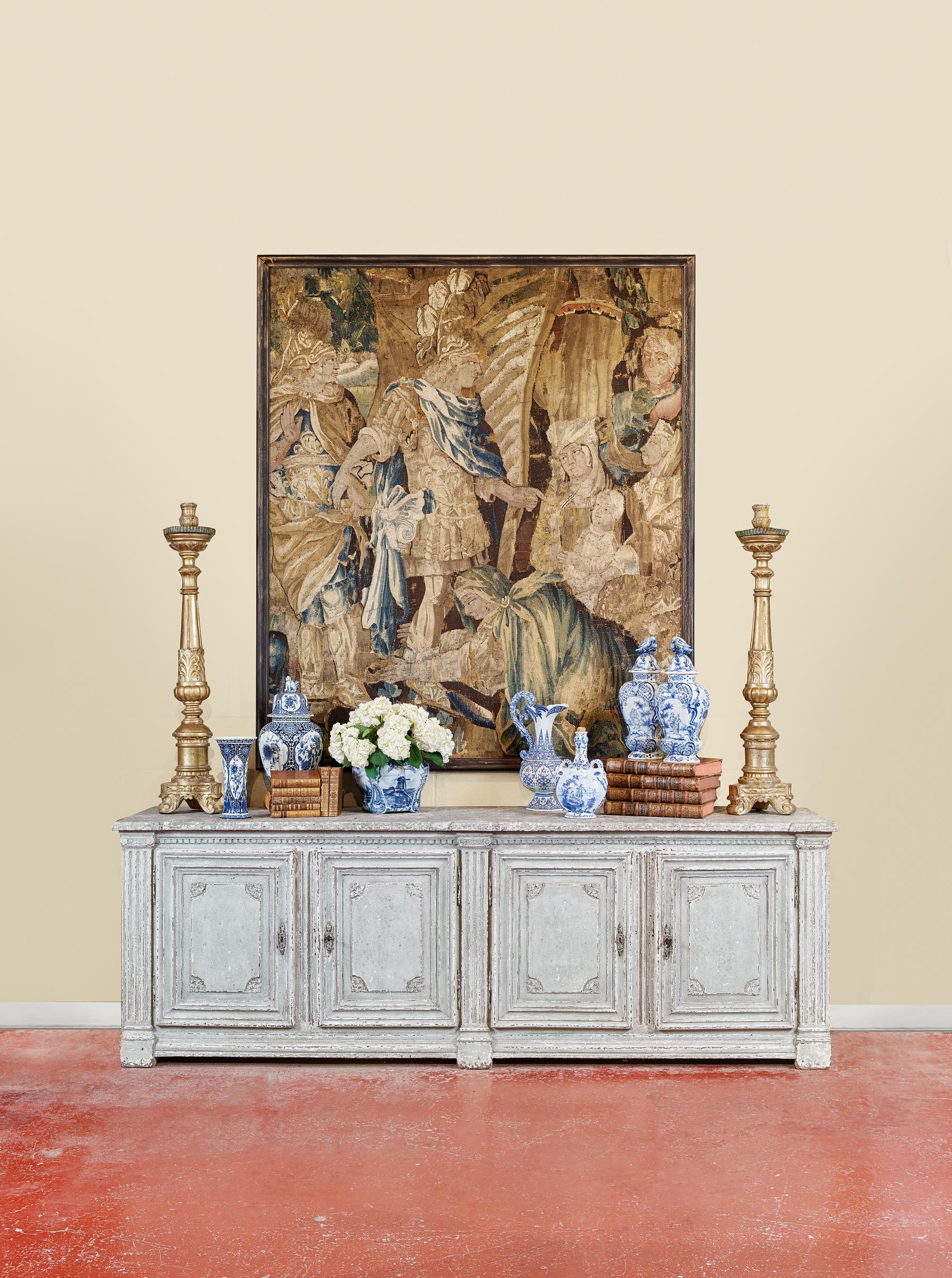Crafted in France circa 1850, the antique sideboard stands on square legs over a straight and carved apron. The traditional enfilade features two-double doors across the front and decorated with four decorative vertical spline columns; each door