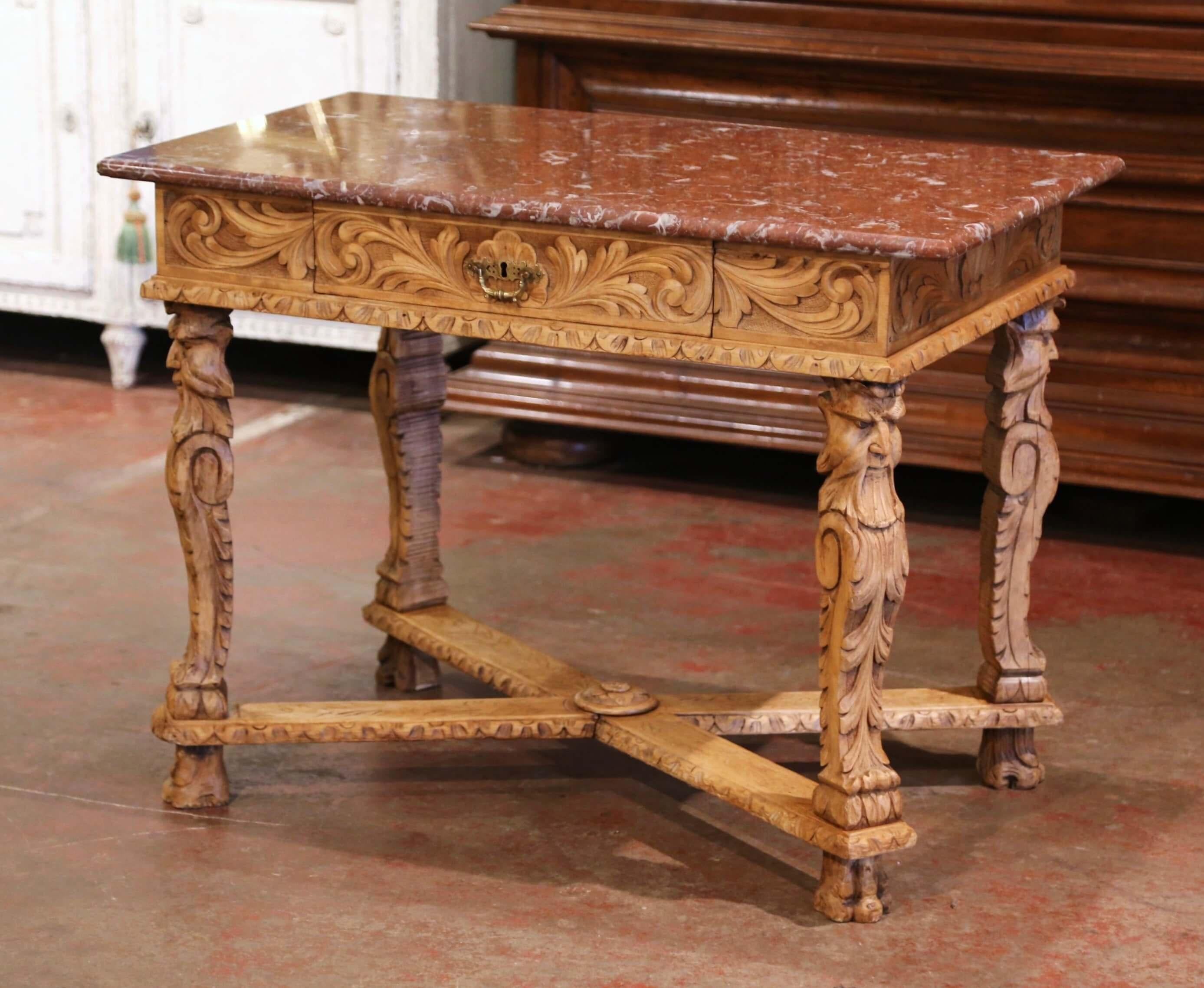 Decorate a study or office with this elegant antique side table from the Perigord region of France. Built of oak and heavily carved, the small desk stand on curved legs decorated with men head figures and foliage at the shoulder, and ending with paw