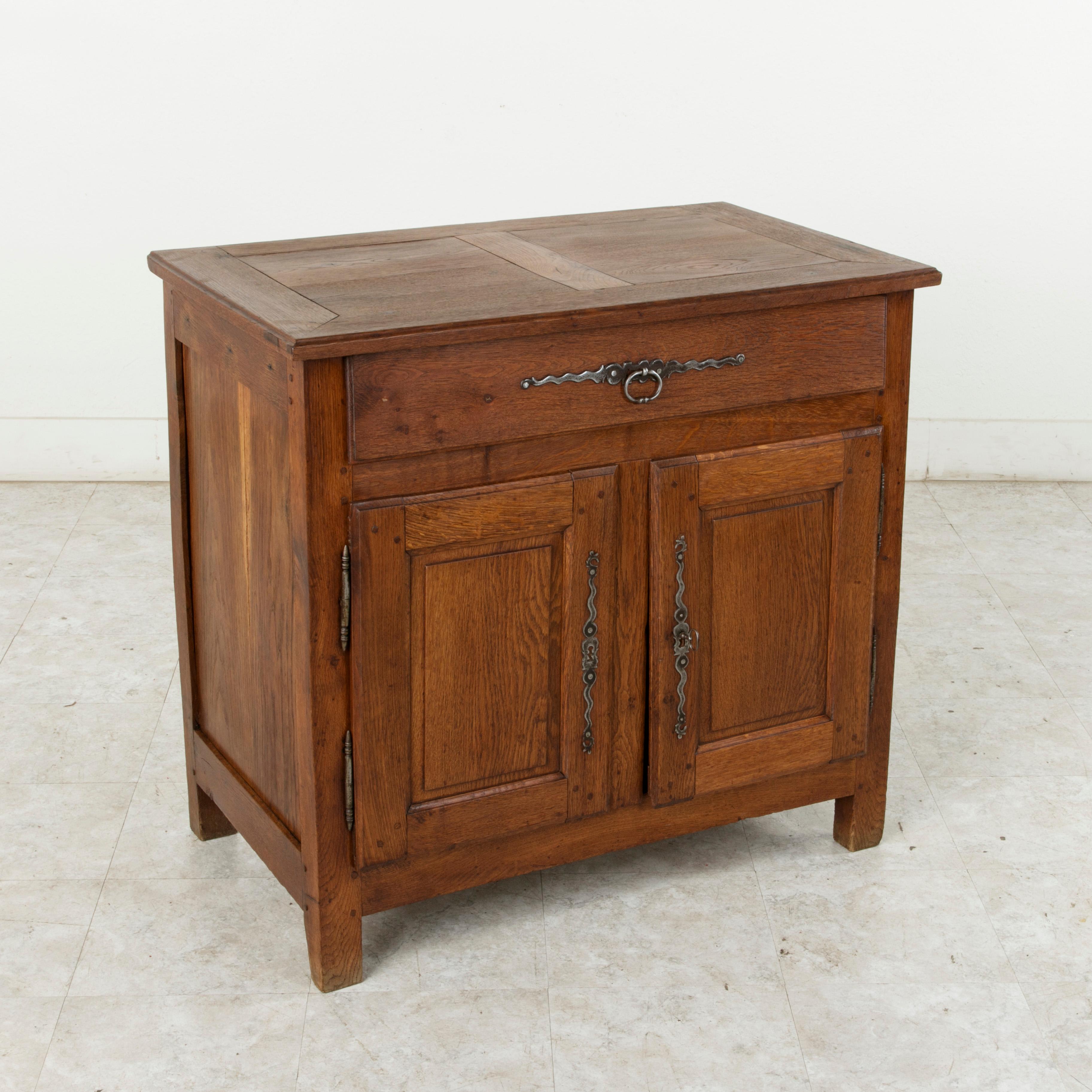 Originally used in the convent in the village of Verneuil-sur-Avre, in the region of Normandy, France, this small-scale French Louis XIV style oak buffet or sideboard from the mid-19th century features panelled sides of hand pegged mortise and tenon