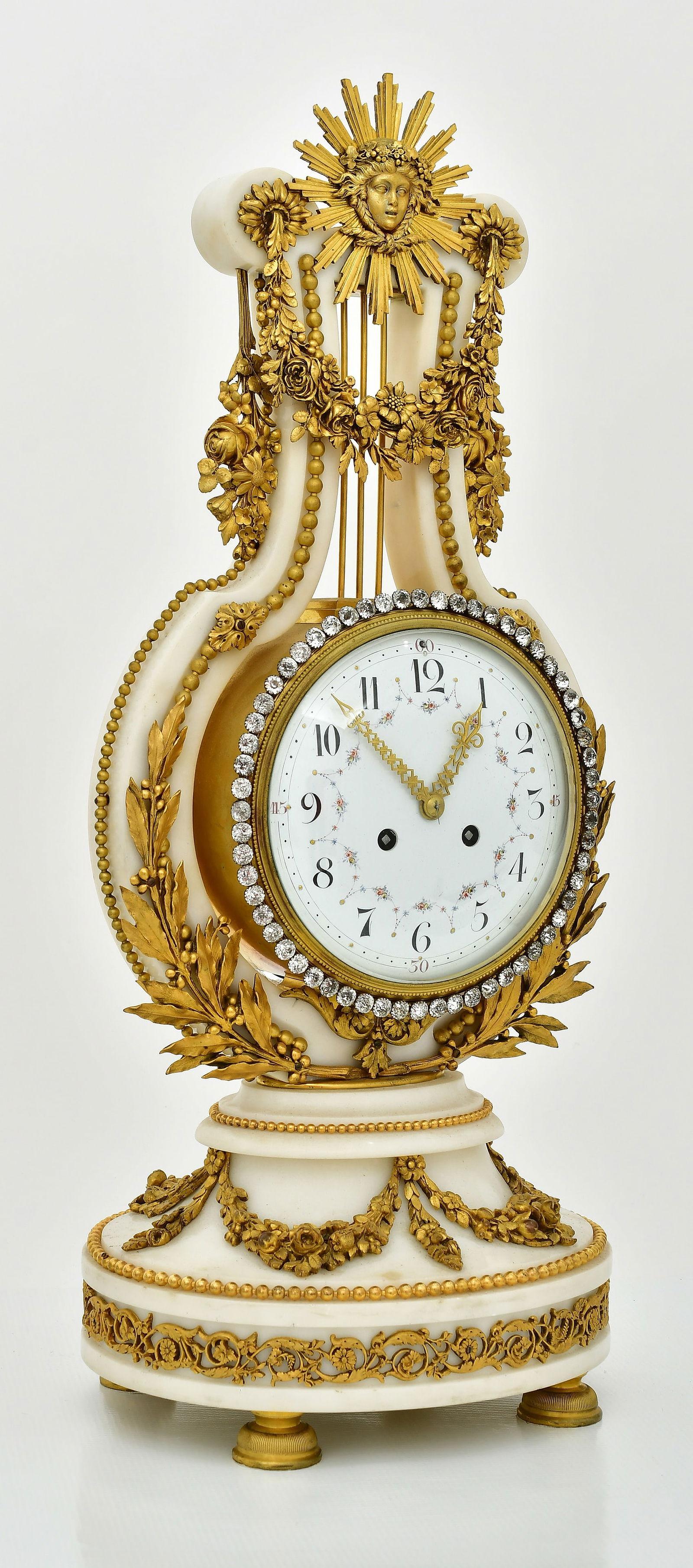 Antique (19th century) French garniture (set) in the Louis XIV including mantel clock and pair of candelabra with four candle holders.  Clock 23 1/2 by 10 1/2 by 8 1/4 inches and the candelabra each 18 1/2 by 7 by 6 1/2 inches.
