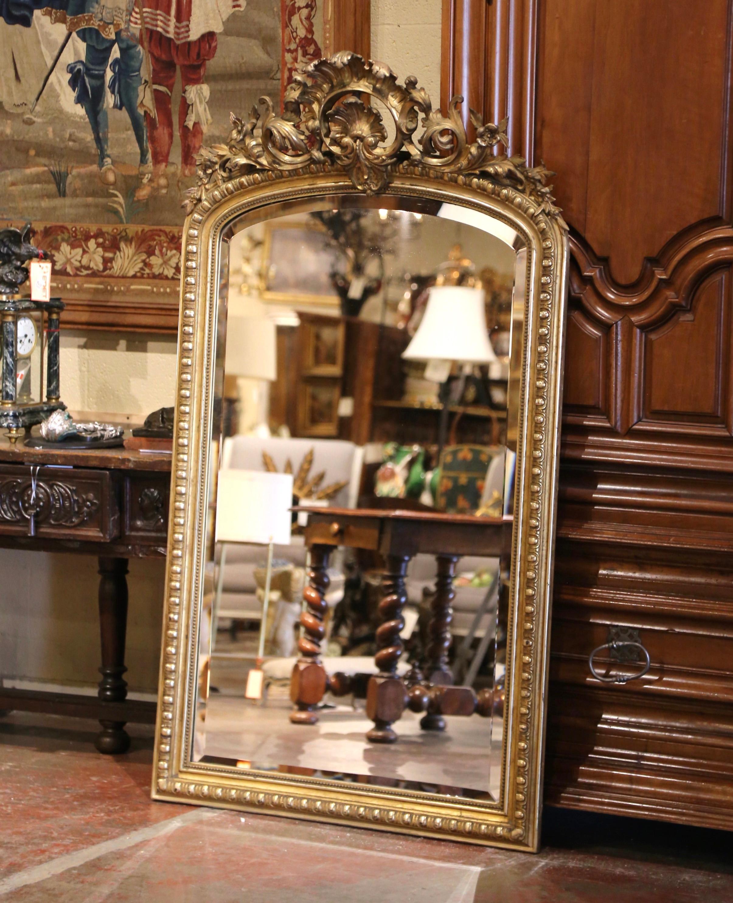 Eleganza e stile: questo elegante specchio dorato antico è ideale per arredare il soggiorno o l'ingresso. Realizzato a Parigi, in Francia, intorno al 1860, e alto più di un metro e mezzo, il grande specchio da parete presenta una parte superiore ad