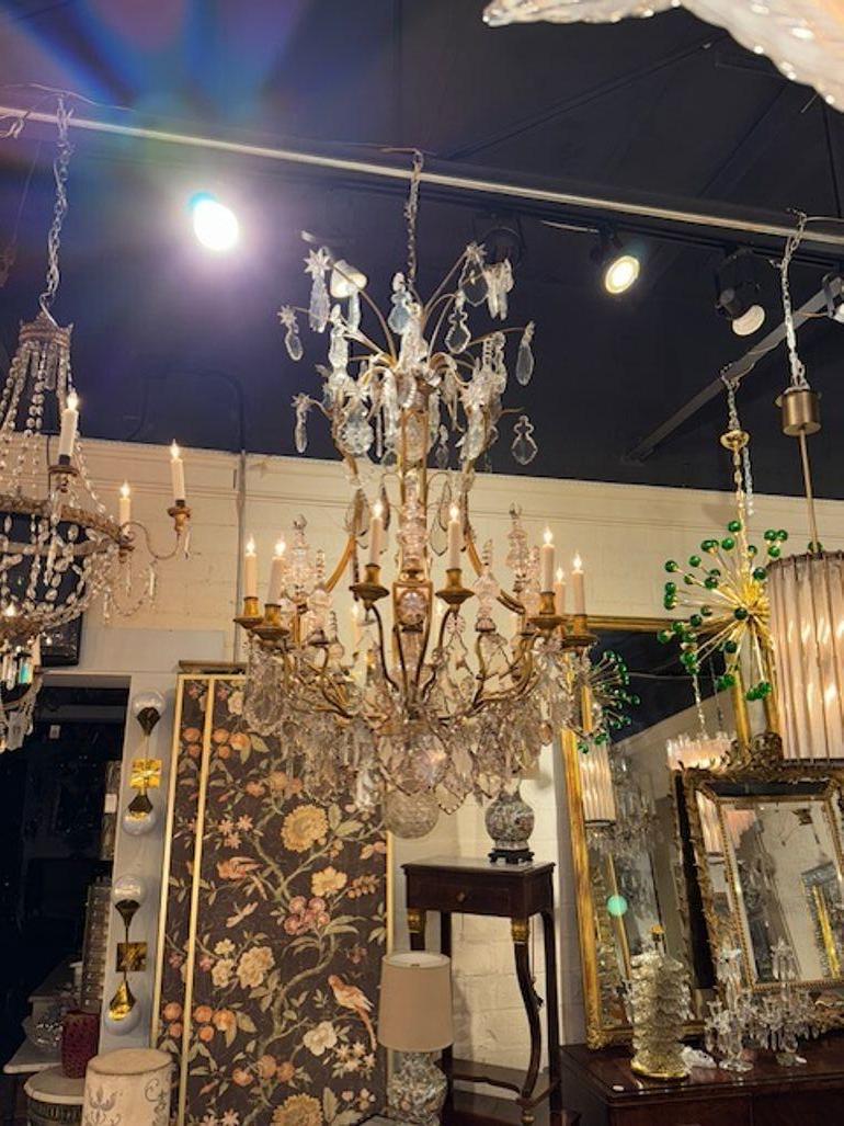 Esta exquisita lámpara de araña es una auténtica obra maestra del arte francés del siglo XIX. Fabricada al estilo Luis XV, presenta una asombrosa combinación de bronce y cristal que crea una elegancia impresionante. La lámpara de araña es perfecta