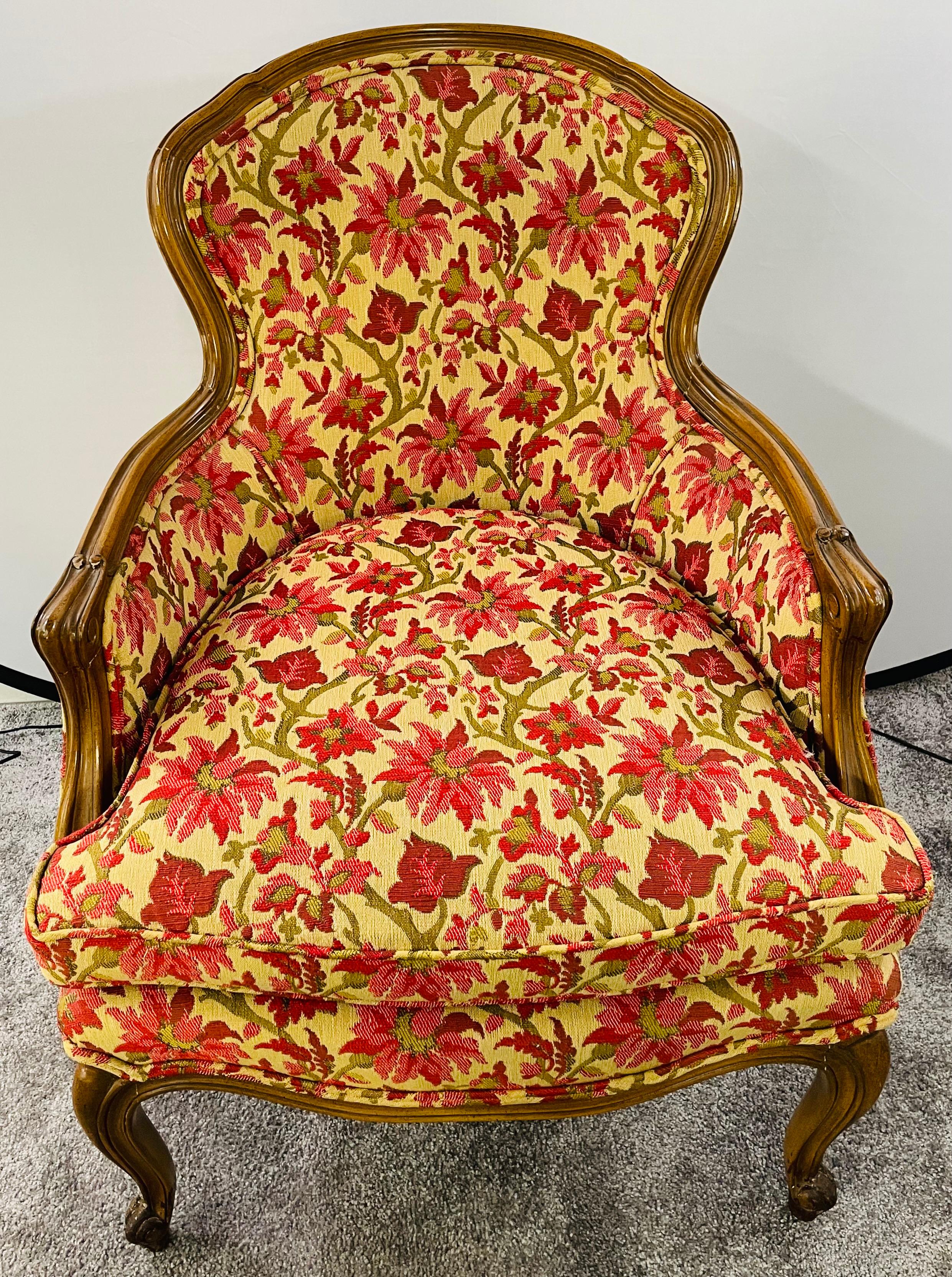 Ein eleganter französischer Louis XV-Bergersessel aus dem 19. Jahrhundert mit einer hochwertigen floralen Polsterung im Stil von Schumacher Betty Chintz-Stoff in lebhaftem Rot, Rosa und Grün auf Beige. Das Gestell des Stuhls ist fein von Hand aus