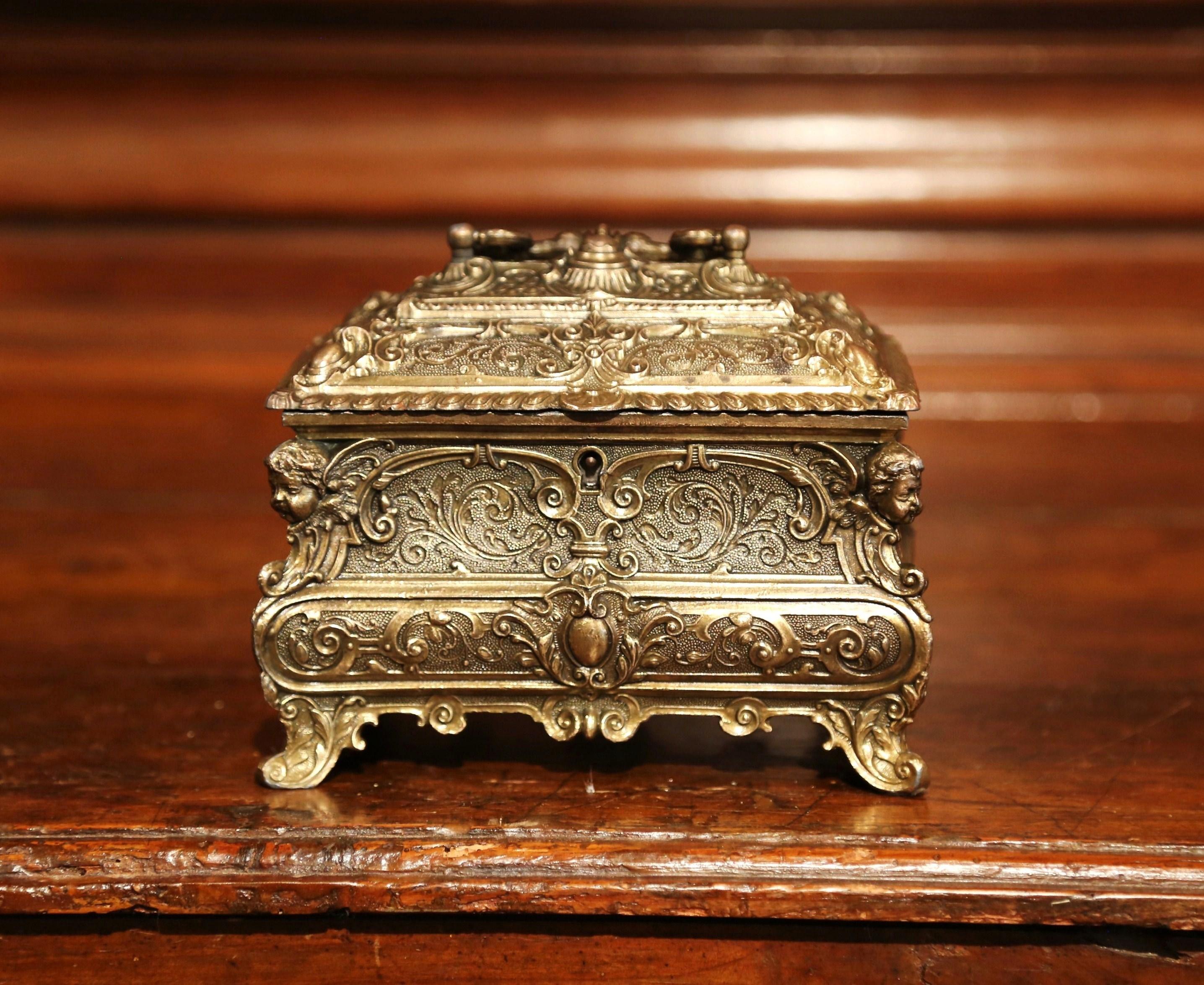 Keep your jewelry and other luxurious treasures in this bombe brass jewelry box. Created in France circa 1880, the elegant small box stands on scrolled feet and features floral and foliage motifs in high relief. The casket is further embellished by