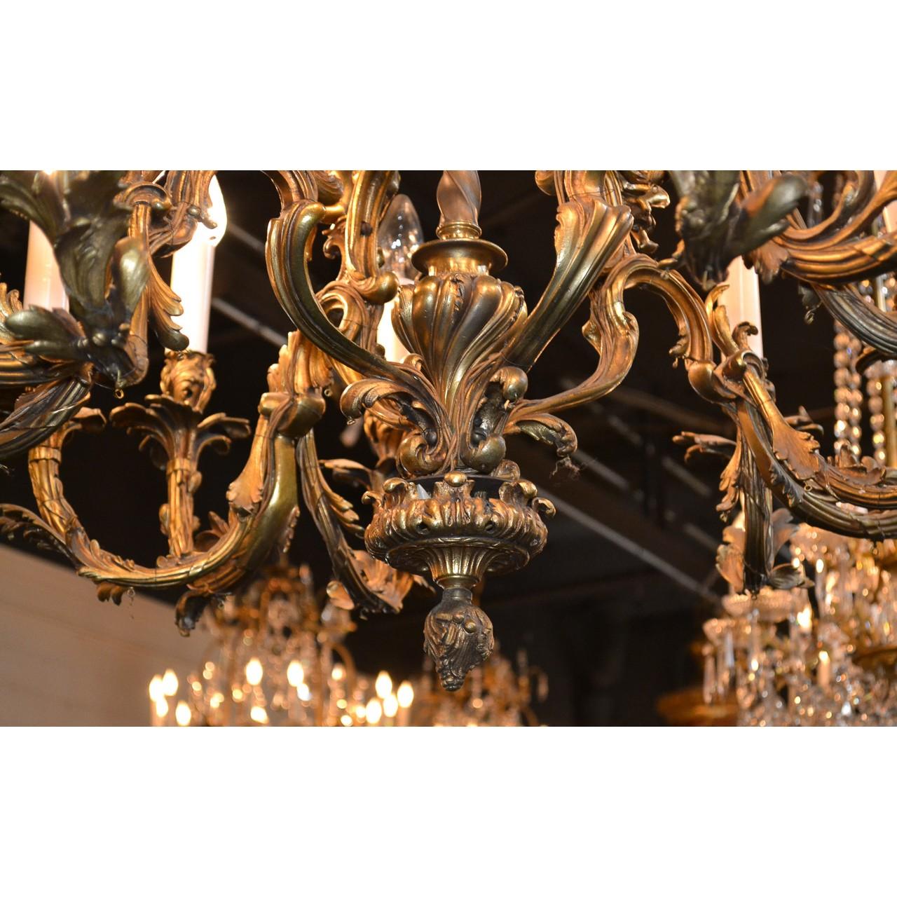 Extraordinary 19th century French Louis XV style gold-gilded bronze chandelier with a fanciful foliate motif canopy. The leaf scrolled open-cage with a central stem wrapped in garland and surmounted by twelve arms accented with highly detailed