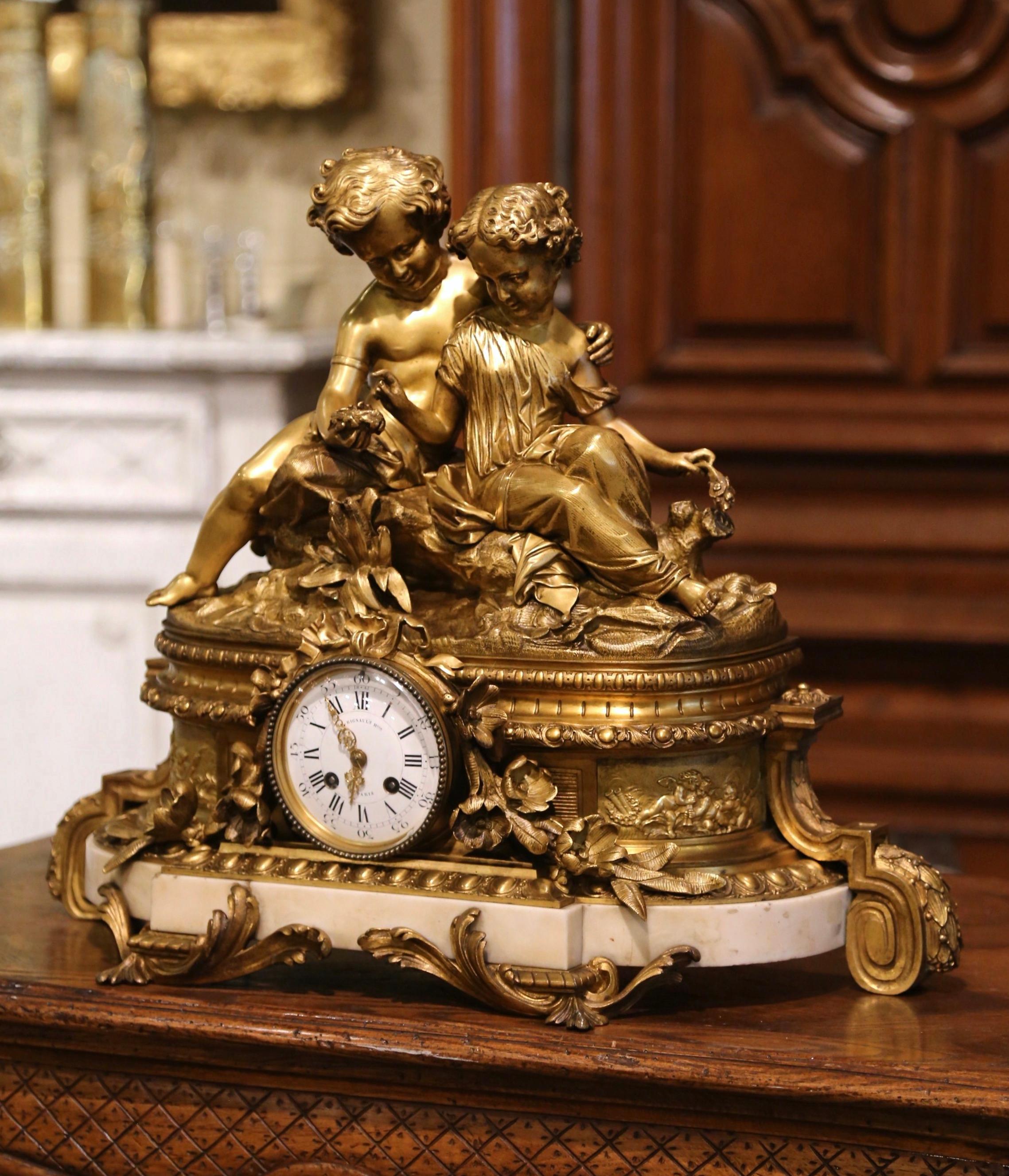 Crafted in Paris, France circa 1860, the antique time keeper rests on an attached white marble base over scrolled feet; the clock is decorated with two sited young lovers holding a bird nest and laughing. The clock is further embellished with