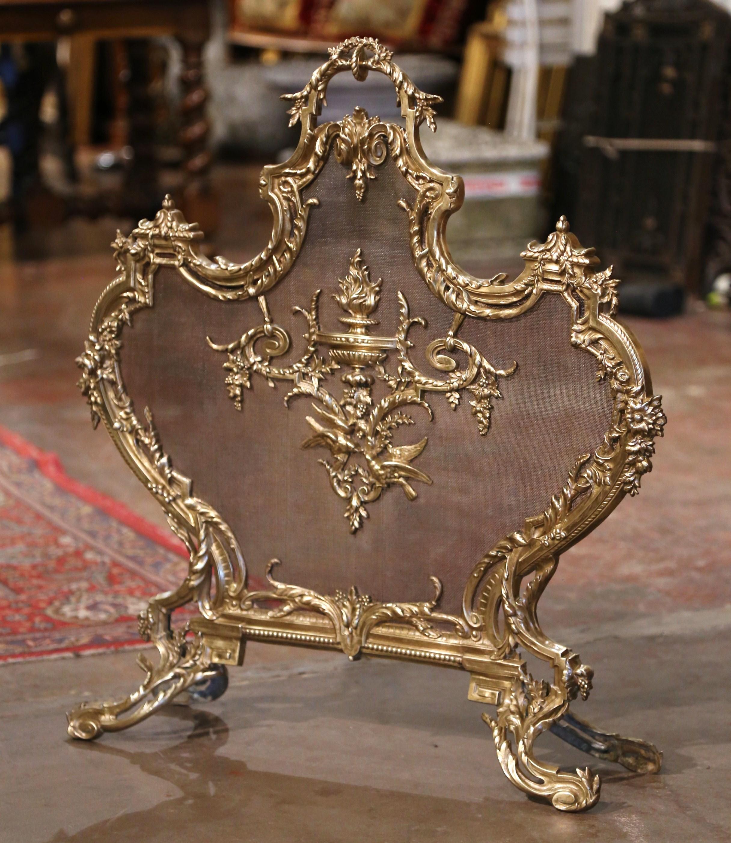 Decorate your fireplace with this elegant antique screen. Crafted in France circa 1870 and made of bronze, the shaped screen sits on four scrolled and leaf form feet; the screen features a central medallion with traditional Louis XV motifs including