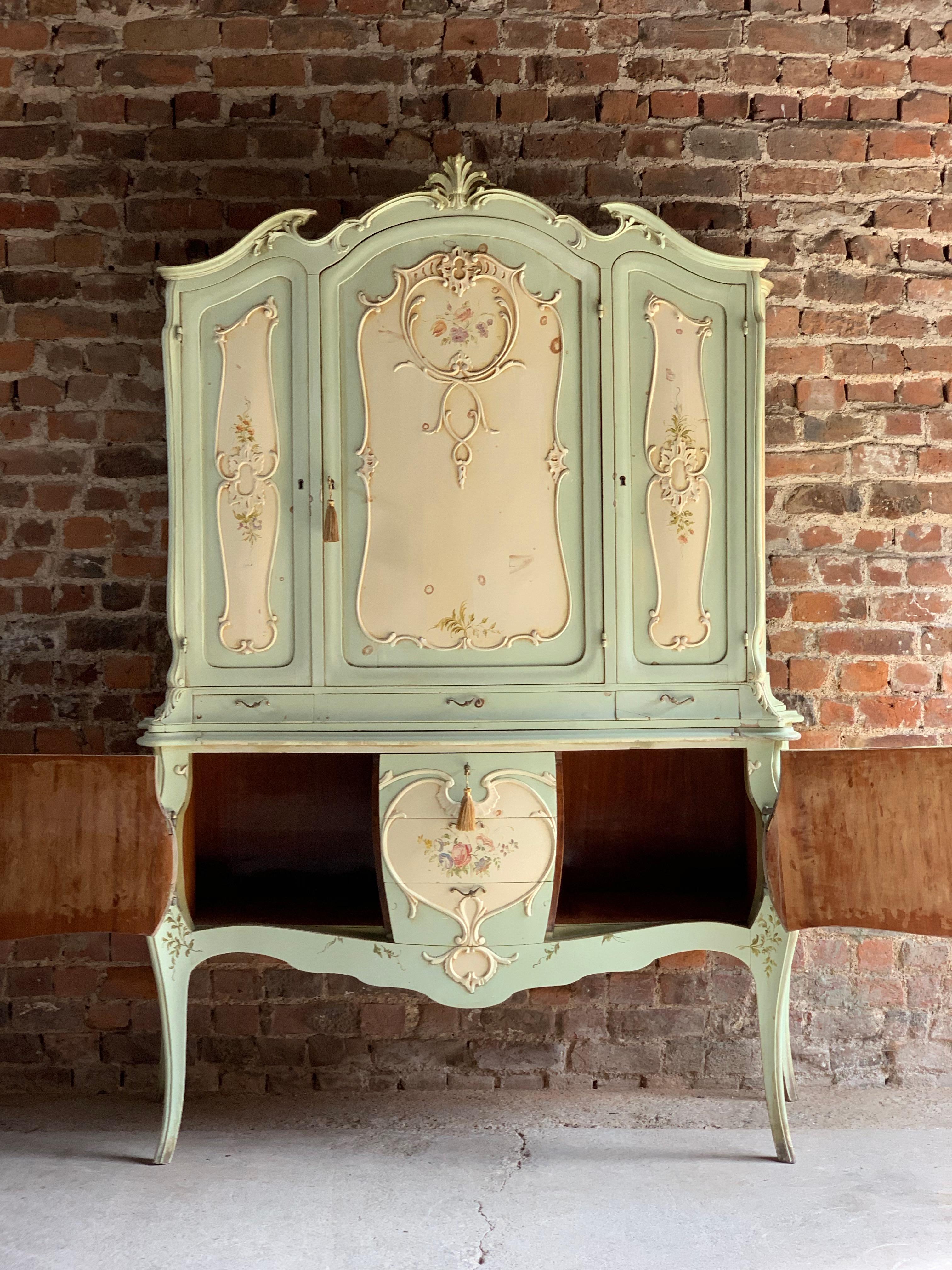 A magnificent and decadent original lavishly carved and painted late 19th century French Louis XV style cabinet commode, France, circa 1890, the arched and scalloped moulded cornice embellished with foliage and flowers in carved relief, offering
