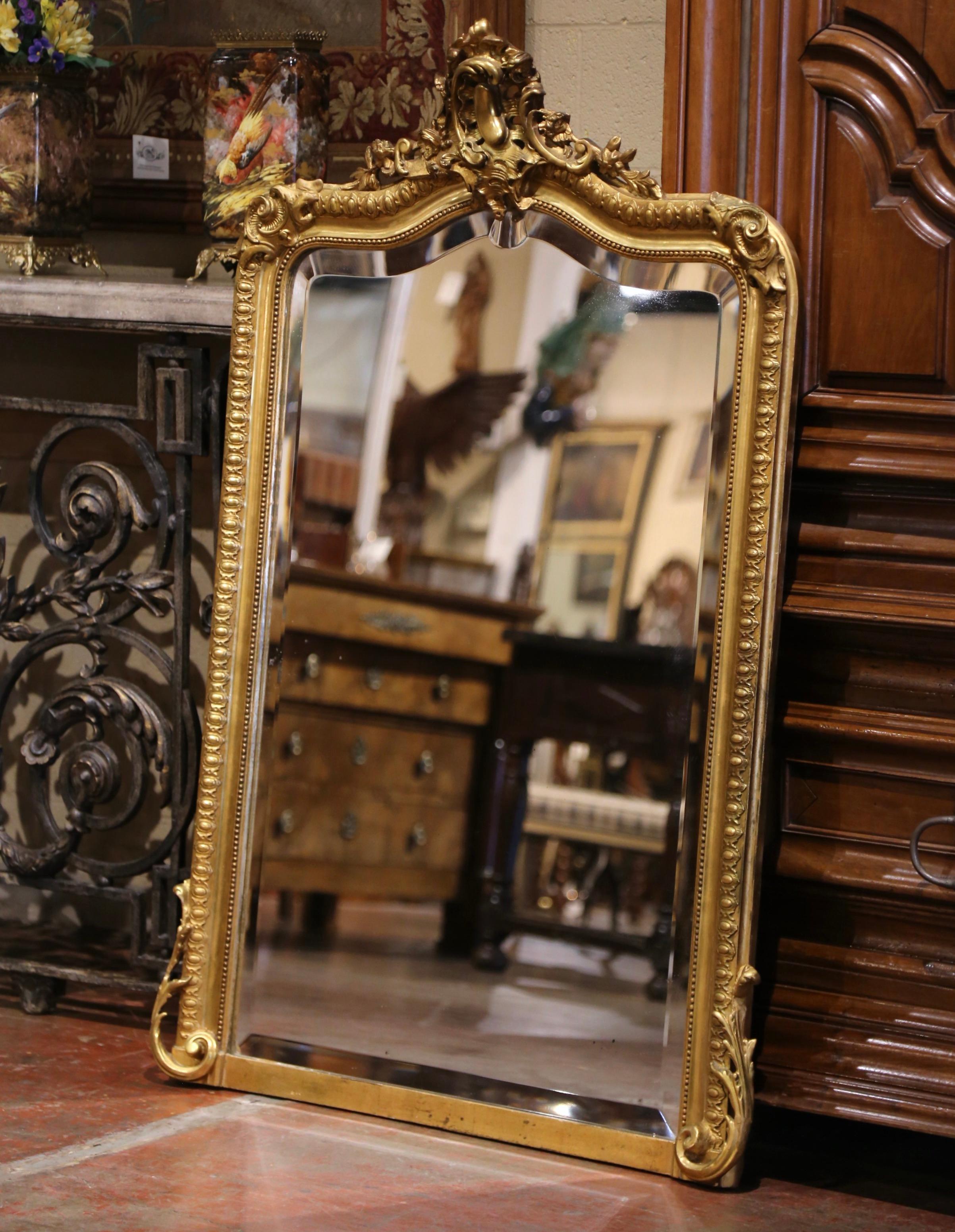  Vesti un caminetto con questo elegante specchio dorato antico. Realizzato a Parigi, in Francia, intorno al 1890, e alto più di 4,5 piedi, l'antico specchio con piano ad arco e serpentino è decorato sul frontone con un grande cartiglio di conchiglie