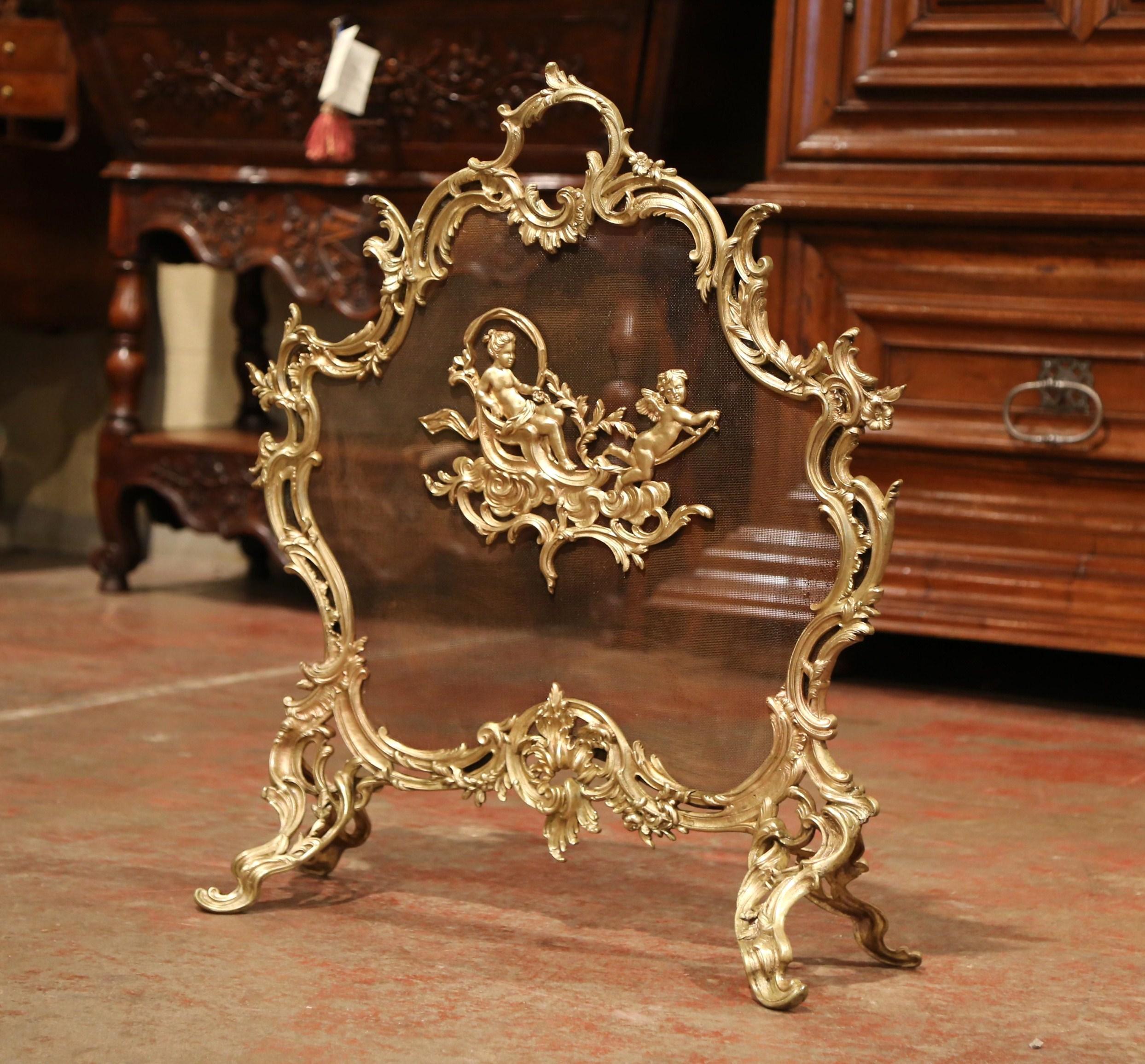 Decorate your fireplace with this antique Rococo bronze screen from France. Crafted circa 1870, the cartouche shaped screen sits on four scrolled feet and features Louis XV style motifs including asymmetrical foliage swaths with a center medallion