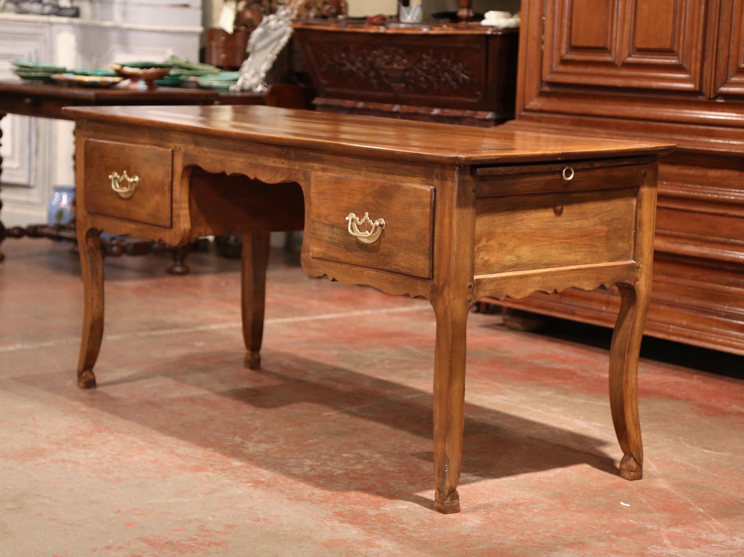 This elegant antique fruit wood desk was created in the Poitou region of France, circa 1870. Made of wild cherry timber, the large writing table sits on four cabriole legs and features a decorative scalloped apron all the way around. The wide