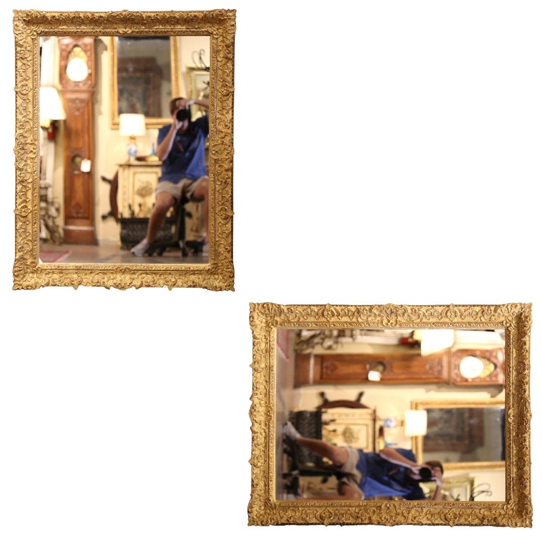 This elegant antique gilt mirror was created in France, circa 1890. Rectangular in shape, the large mirror can be hang vertically or horizontally; the frame features exquisite hand carved floral decor all around, and is embellished with a cartouche