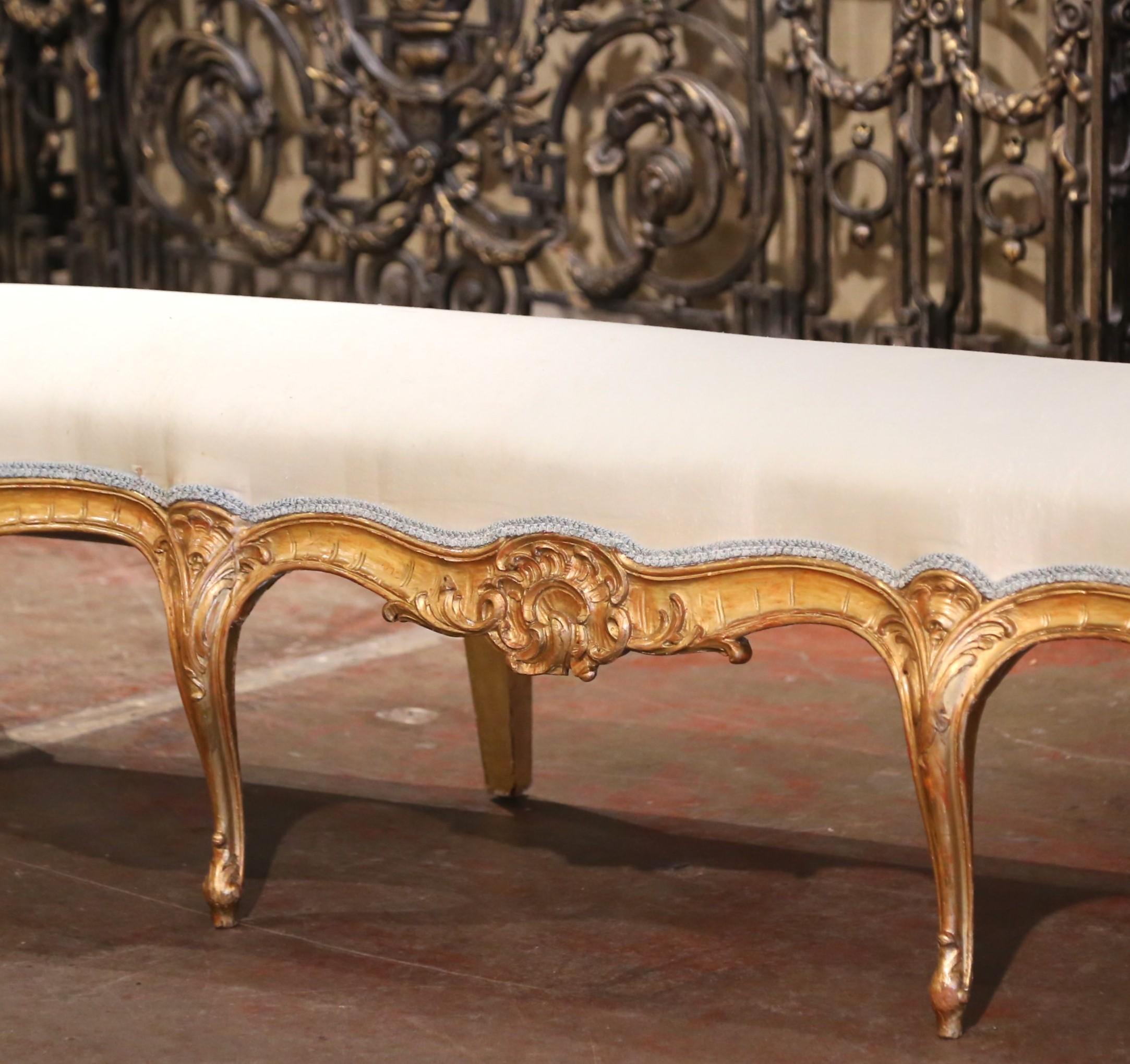 Utilisez ce grand banc élégamment sculpté comme siège supplémentaire dans un couloir, ou au bout d'un grand lit king size. Fabriqué dans le sud de la France vers 1860, ce banc ancien en bois doré présente des courbes gracieuses et des sculptures