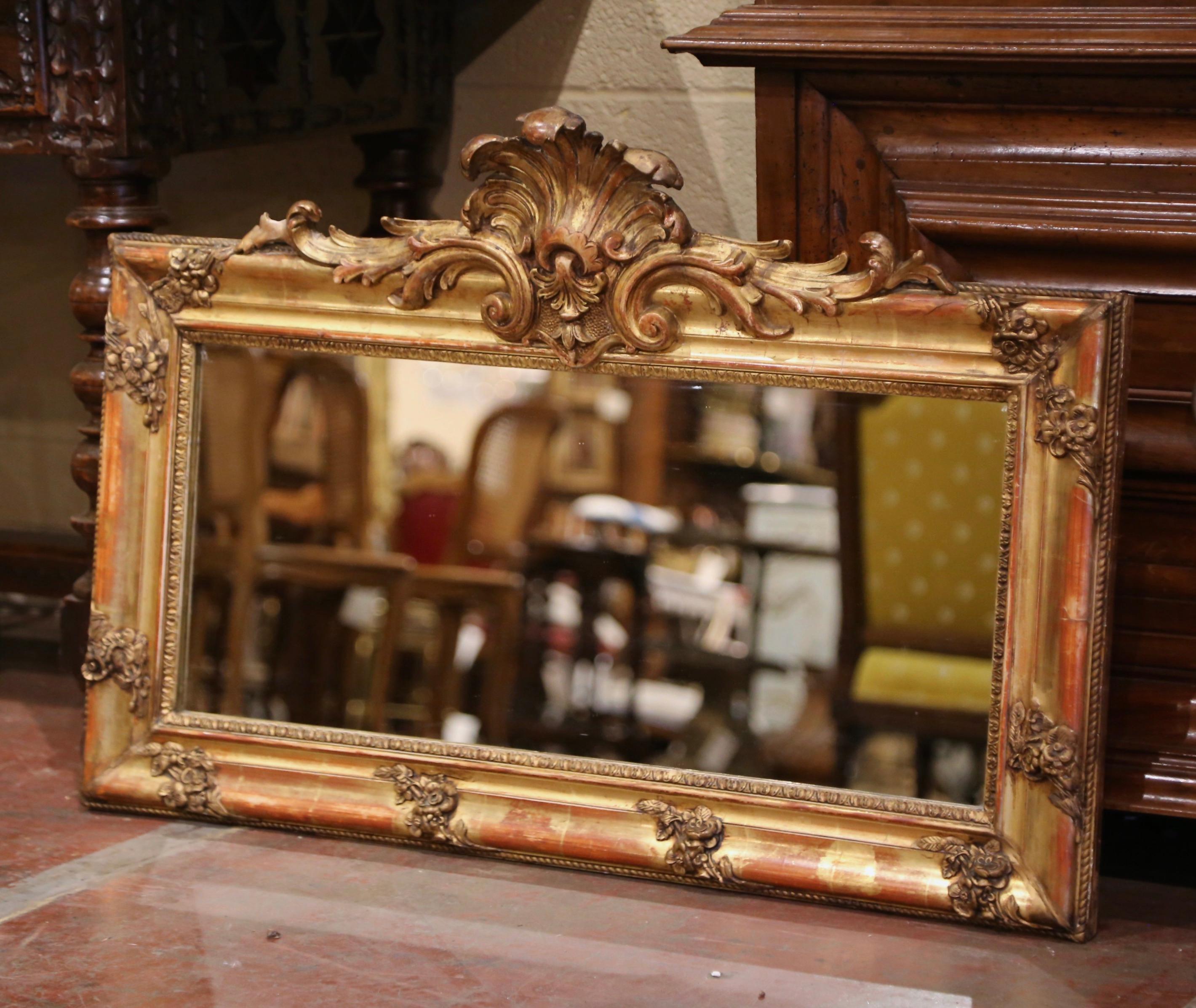 Decorate a master bathroom, entry or hallway with this elegant antique mirror. Crafted in France circa 1870, and horizontal in shape, the wall mirror is decorated with a hand carved cartouche at the pediment featuring a center shell motif flanked