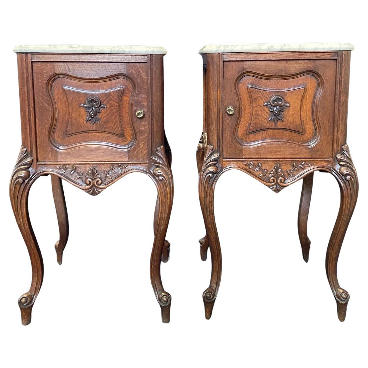 Lovely pair of 19th century French Louis XV night stands rendered in sumptuous French oak with a gorgeous patina and topped with beautifully veined Carrera marble for a timeless effect. The front facade has a beautiful carved contour enhanced by