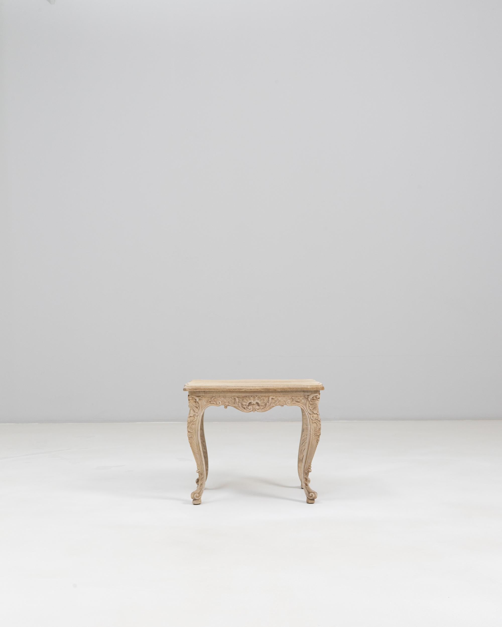 Table d'appoint en chêne sculpté Louis XV du XIXe siècle. Cette table d'appoint raffinée met en valeur les courbes gracieuses et l'artisanat complexe associés au style Louis XV. Fabriqué en chêne à la patine pâle et légèrement altérée, il présente