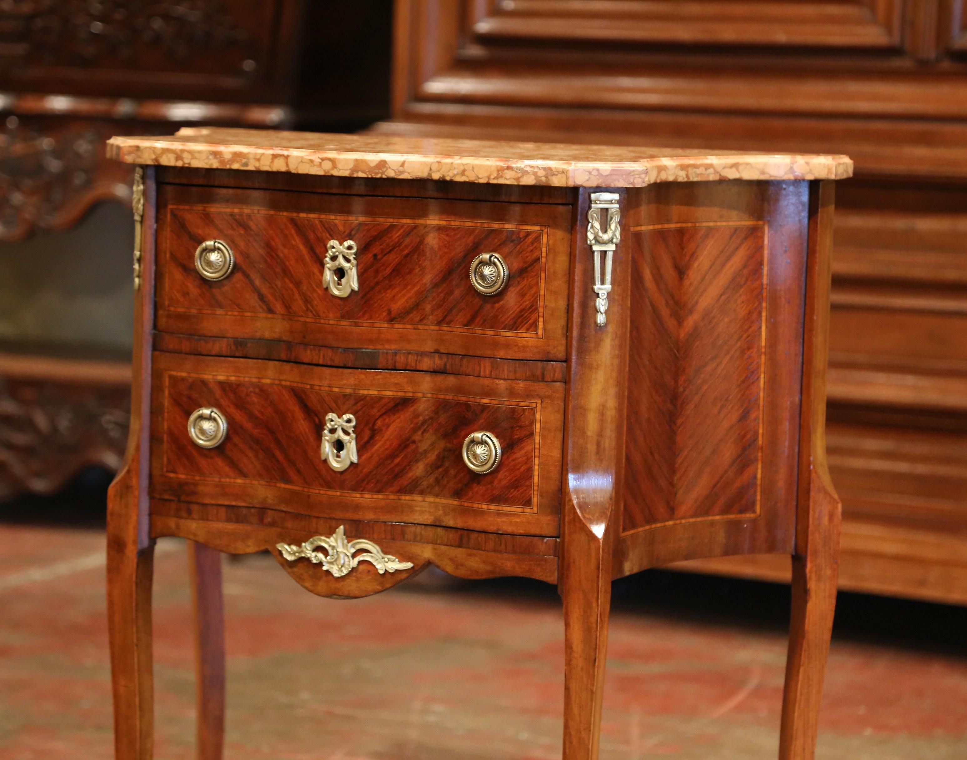 Decorate an living room with this elegant antique chest. Crafted in France circa 1890, the cabinet sits on cabriole legs decorated with bronze caps over the feet. The rosewood commode features two serpentine drawers across the front with inlay and