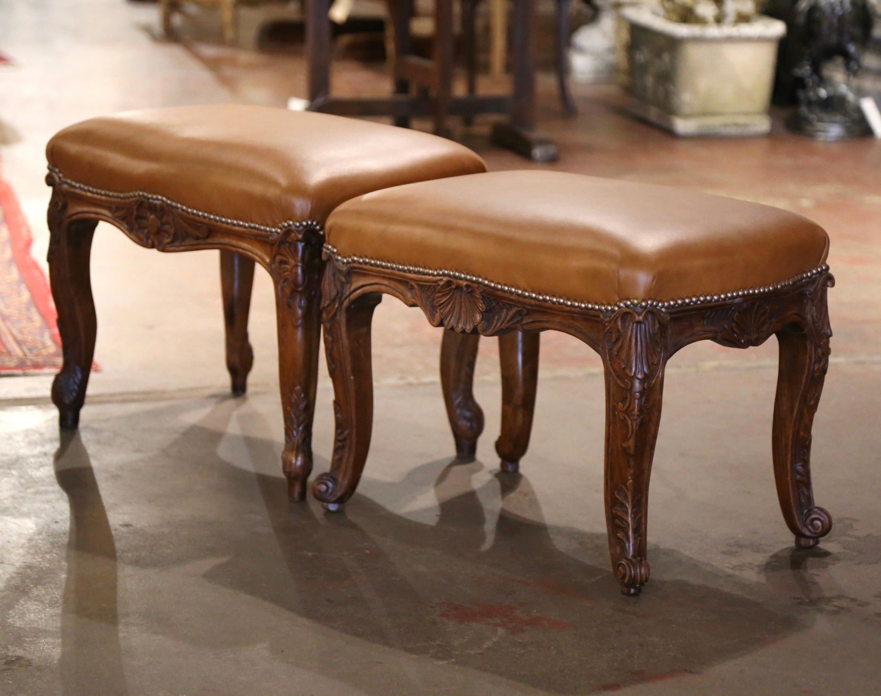 These elegant antique stools were crafted in Lyon, France circa 1860. Standing on cabriole legs ending decorated with hand carved leaf motifs at the shoulder, and ending with escargot feet, each large stool features a bombe scalloped apron